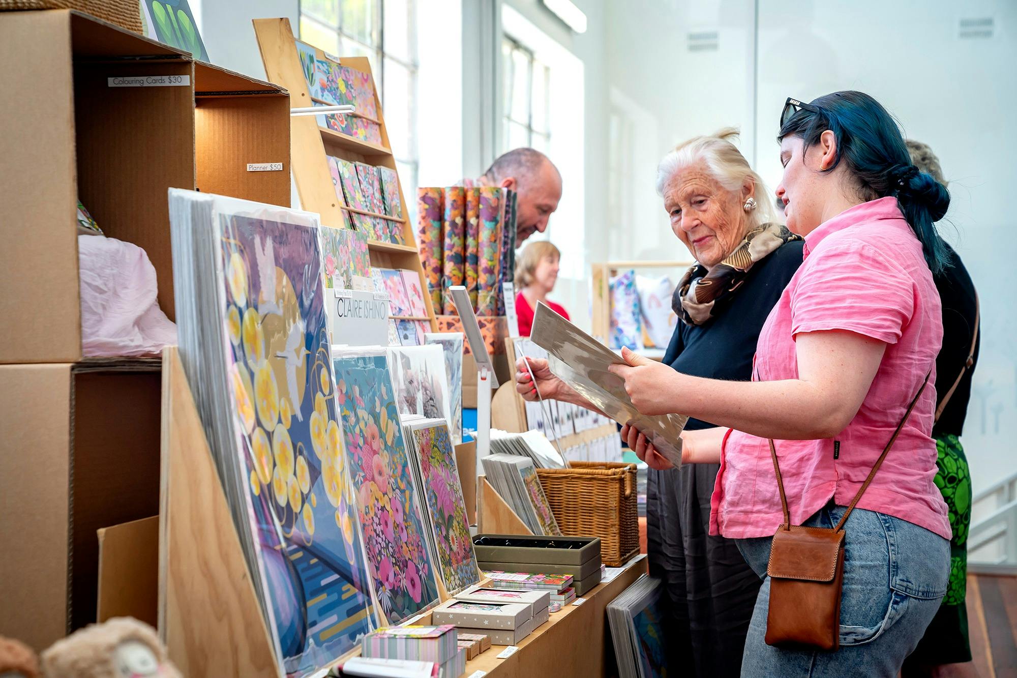 Browsing colorful art prints and handmade goods at FABRIK Arts + Heritage Handmade Christmas Market