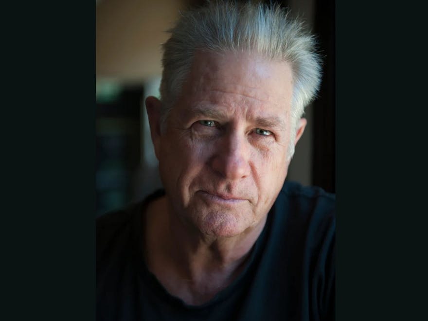Headshot of man with short hair wearing a black shirt