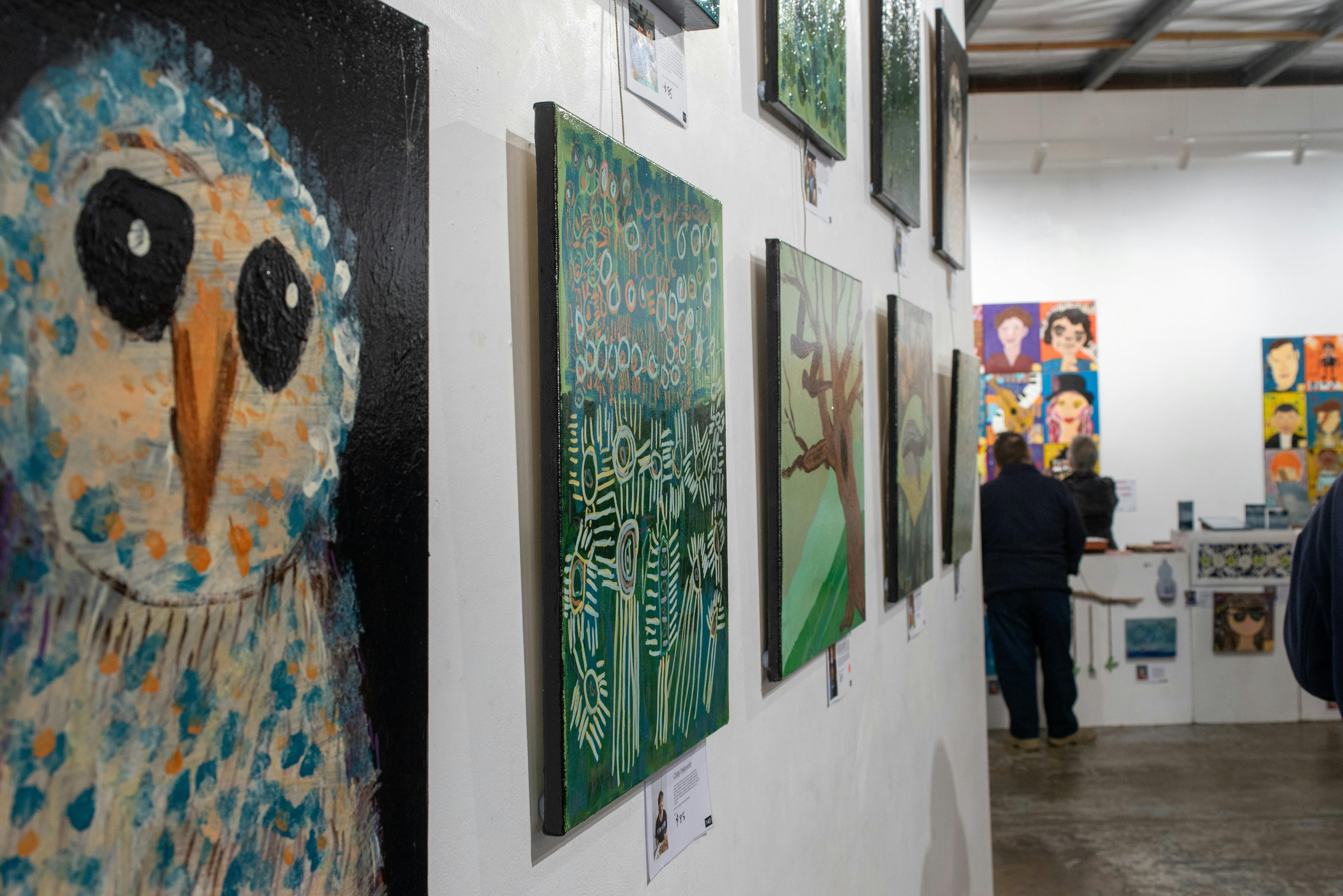 A view of a gallery wall showing different art works