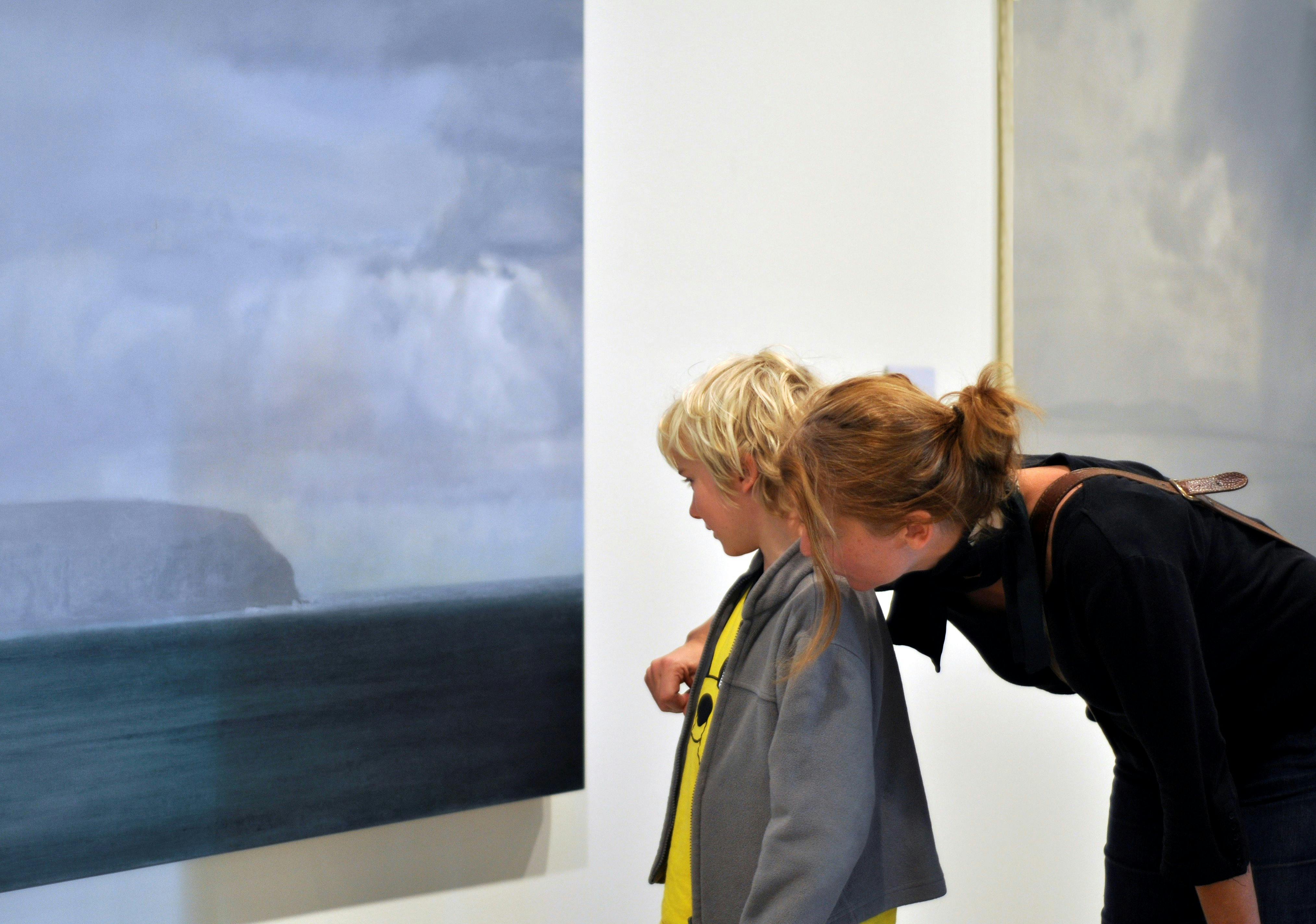 Patrons viewing a painting in the gallery