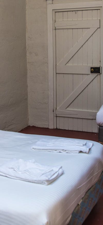 a queen bed and single bed inside the Pisa cottage at Cuppacumbalong