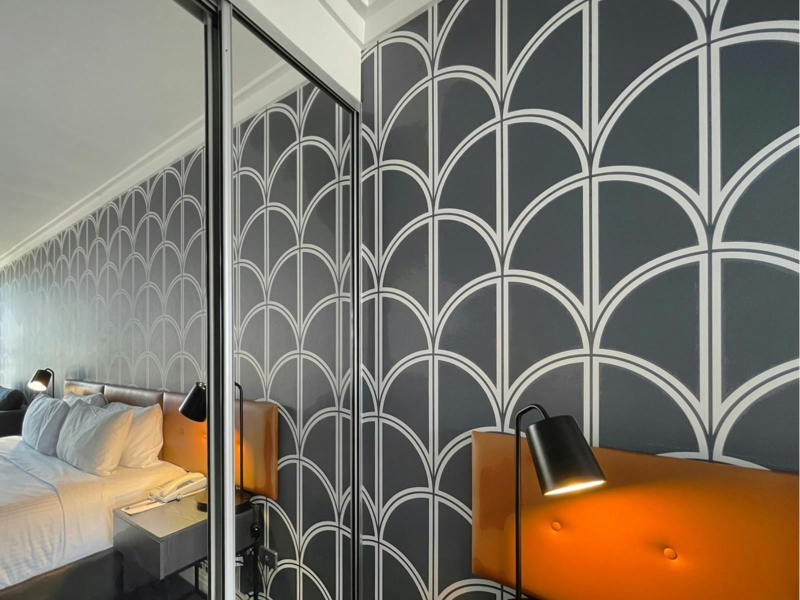 Built-in wardrobe with mirrored doors and study nook.