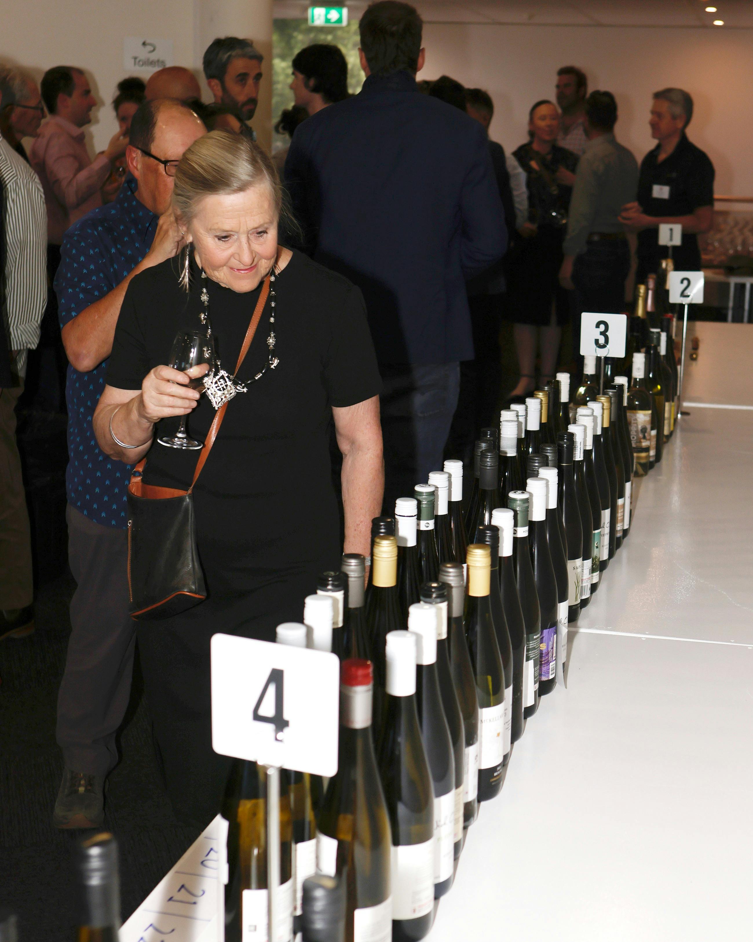 Lady looking at all the bottles of wine for tasting