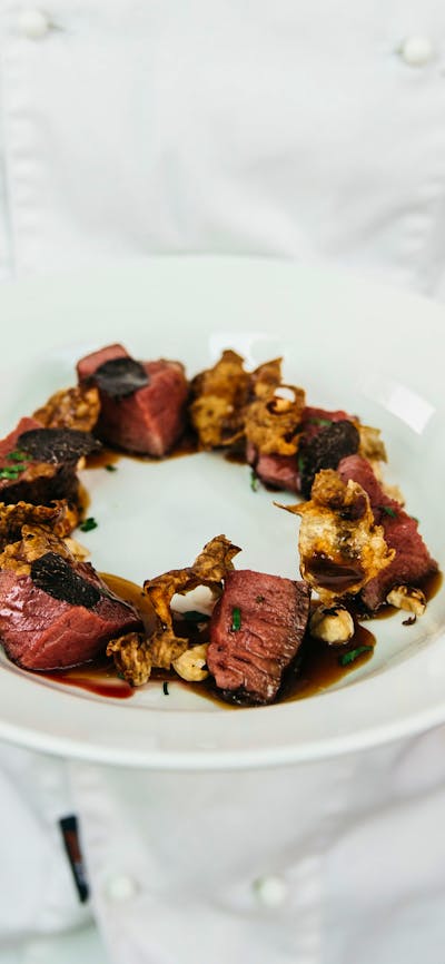 Chef holding a plate containing a dish made with truffle