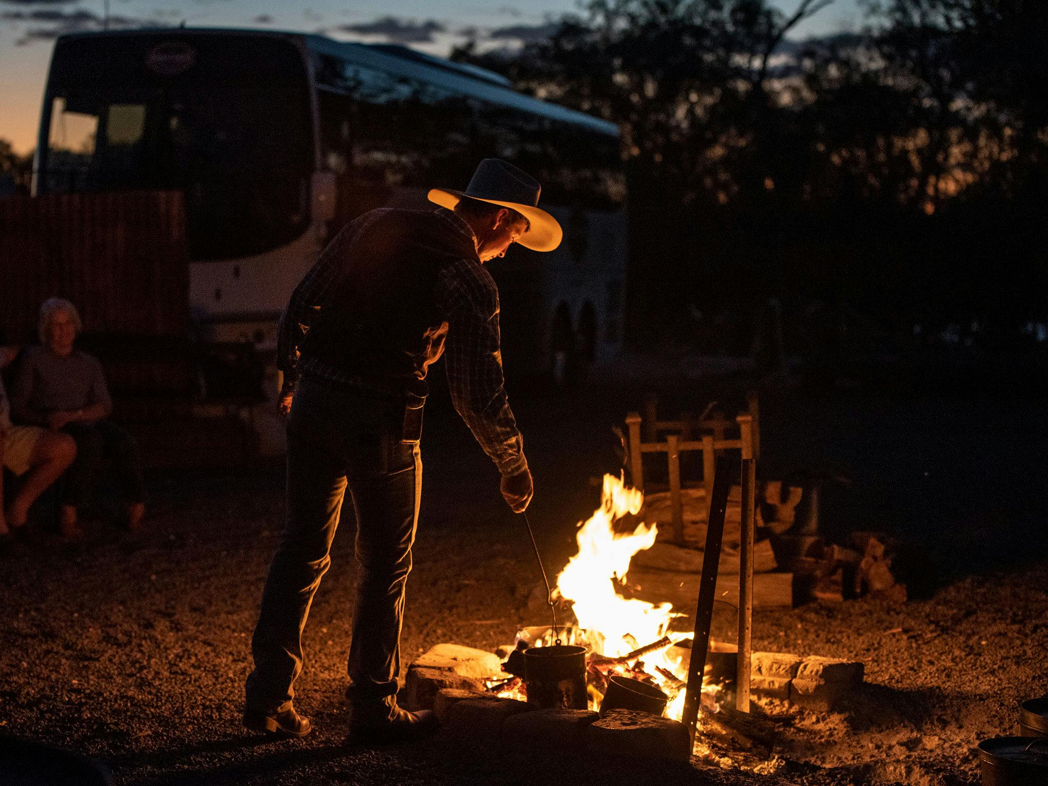 Young stockman, Jeremy Kinnon stoking the camp fire Young stockman, Jeremy Kinnon stoking the camp fire