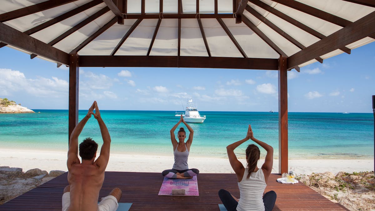 Morning yoga session on Anchor Bay beach at Lizard Island
