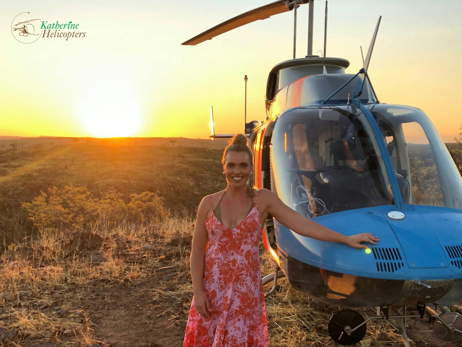 Abbey Holmes standing in front of helicopter watching the nt sunset