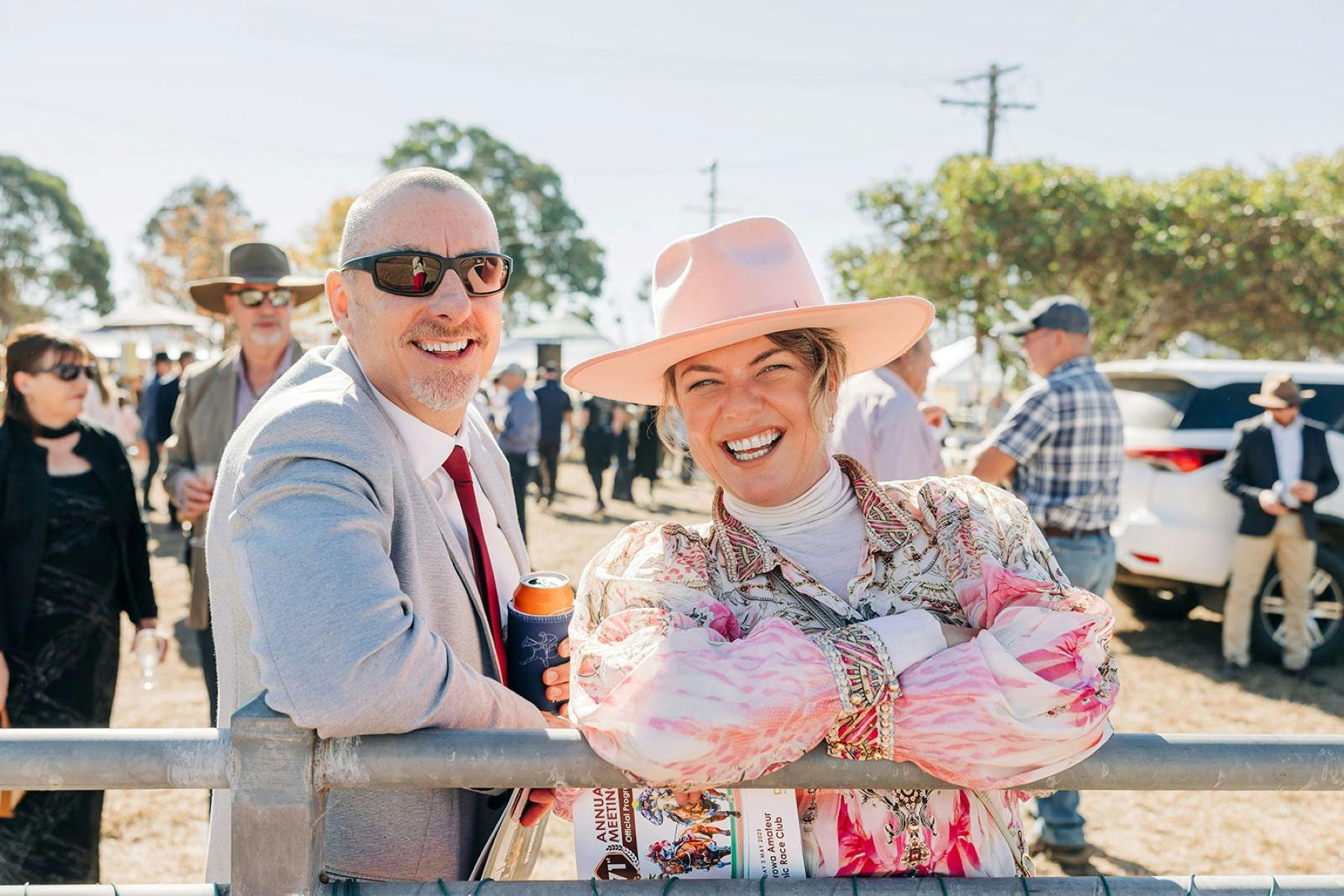 A man and woman in fancy dress for the races.