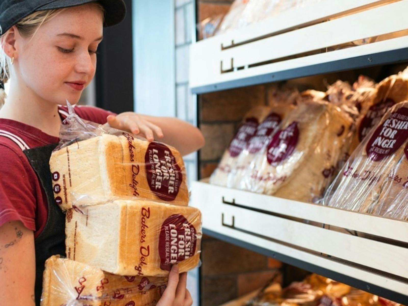 Girl stacking shelves with bread