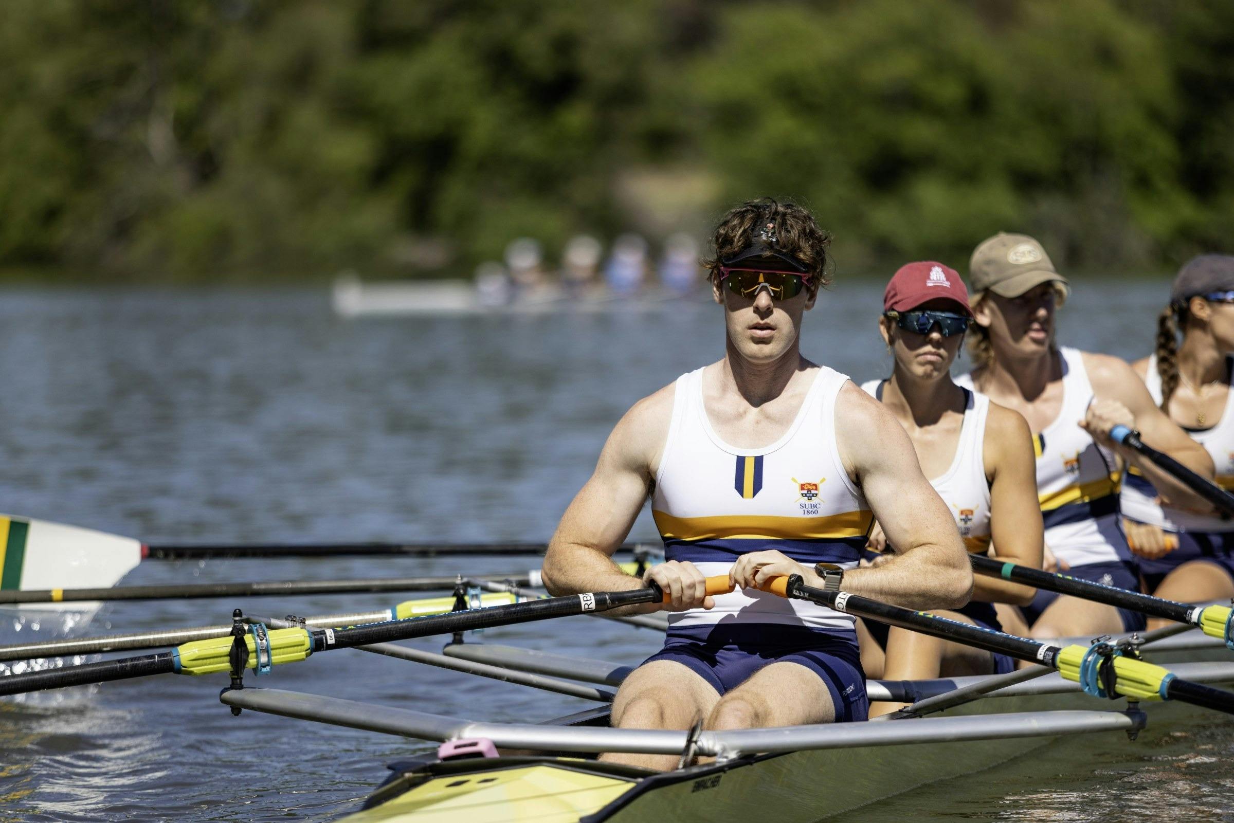 Rowers in a mixed crew sitting in their boat on the lake