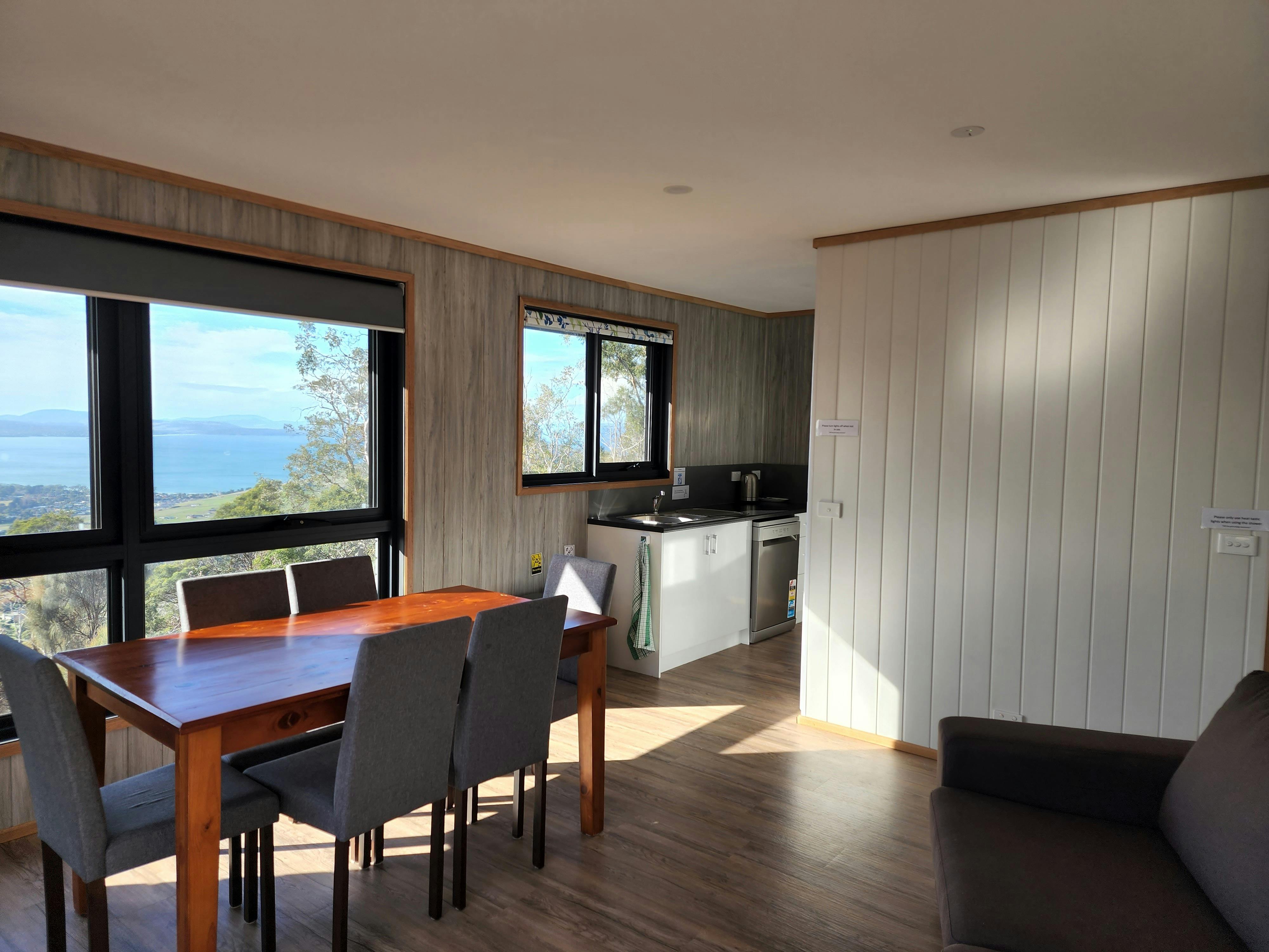 Open-plan living and dining area at Devil House with seating, dining table and large windows