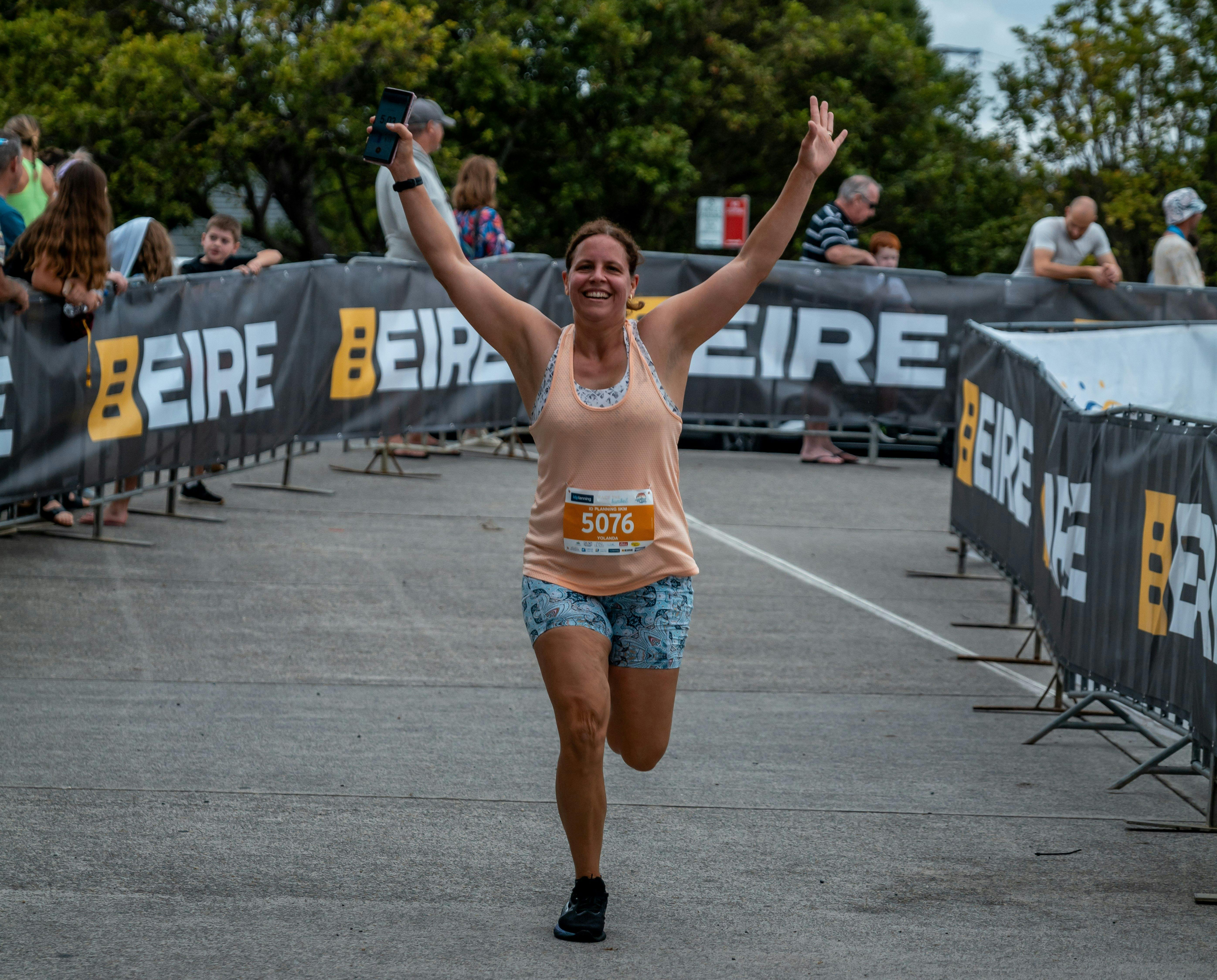 A woman celebrating as she crosses the finish line