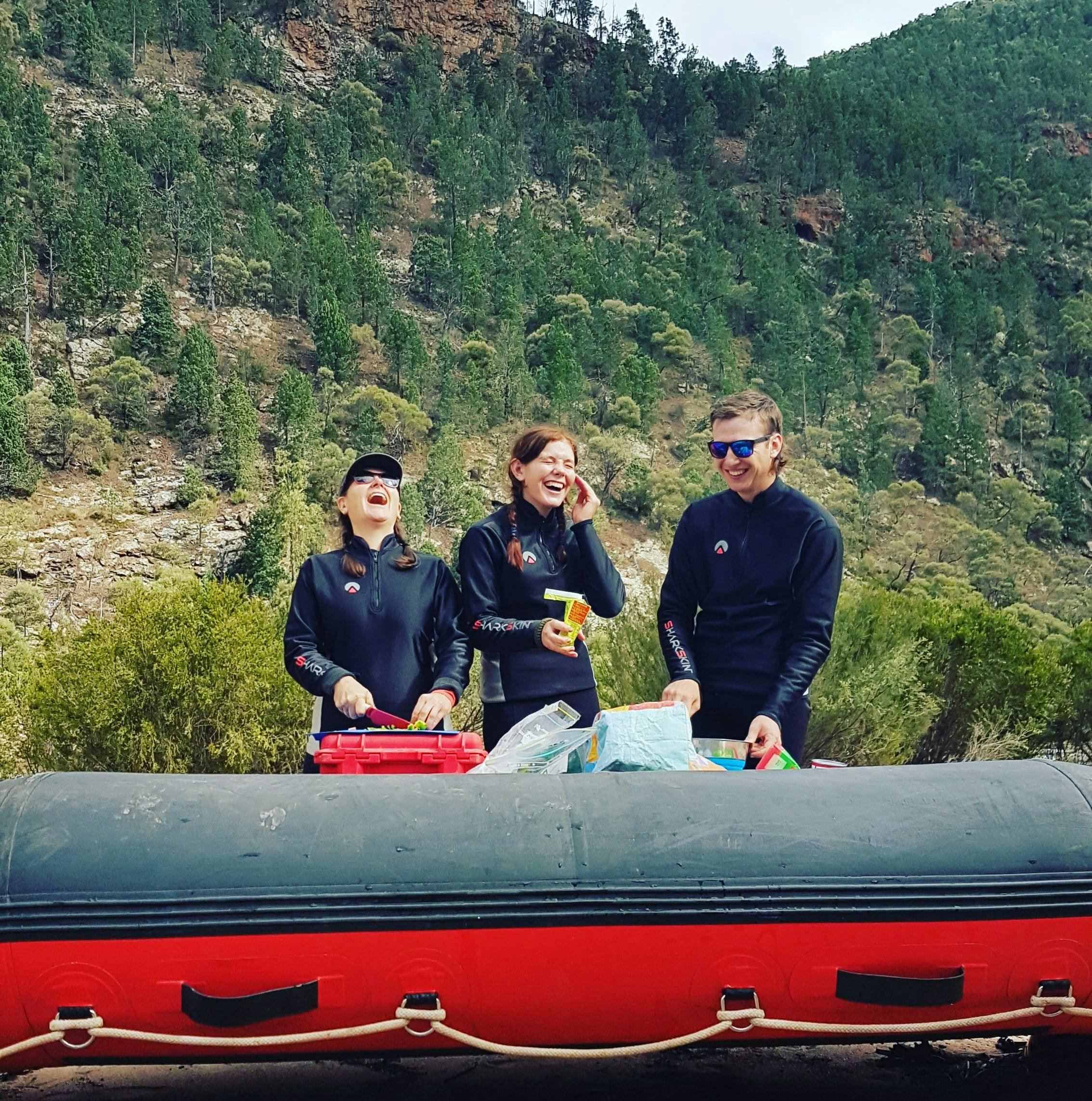 Happy clients getting ready for lunch in a remote part of the Snowy River with raft as a table.