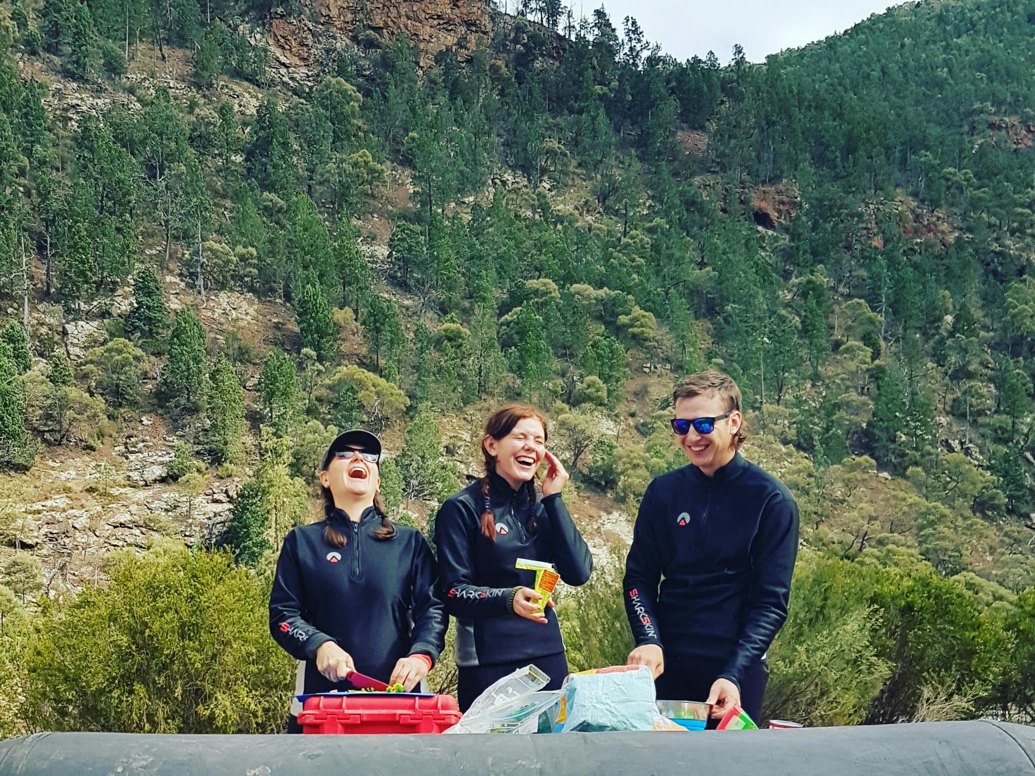 Happy clients getting ready for lunch in a remote part of the Snowy River with raft as a table.