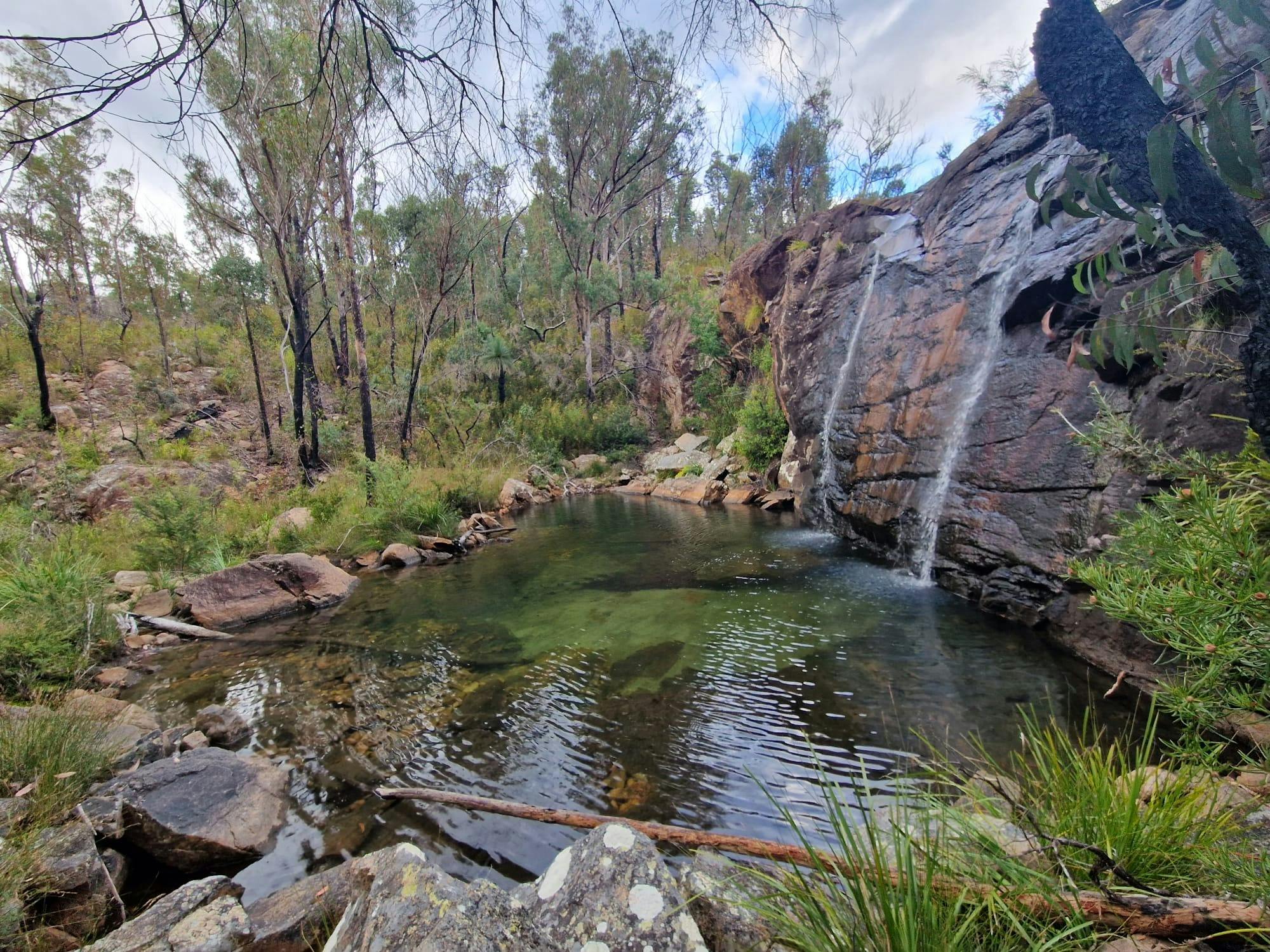 twin waterfall into a stunning sand lagoon surrounded by granite boulders