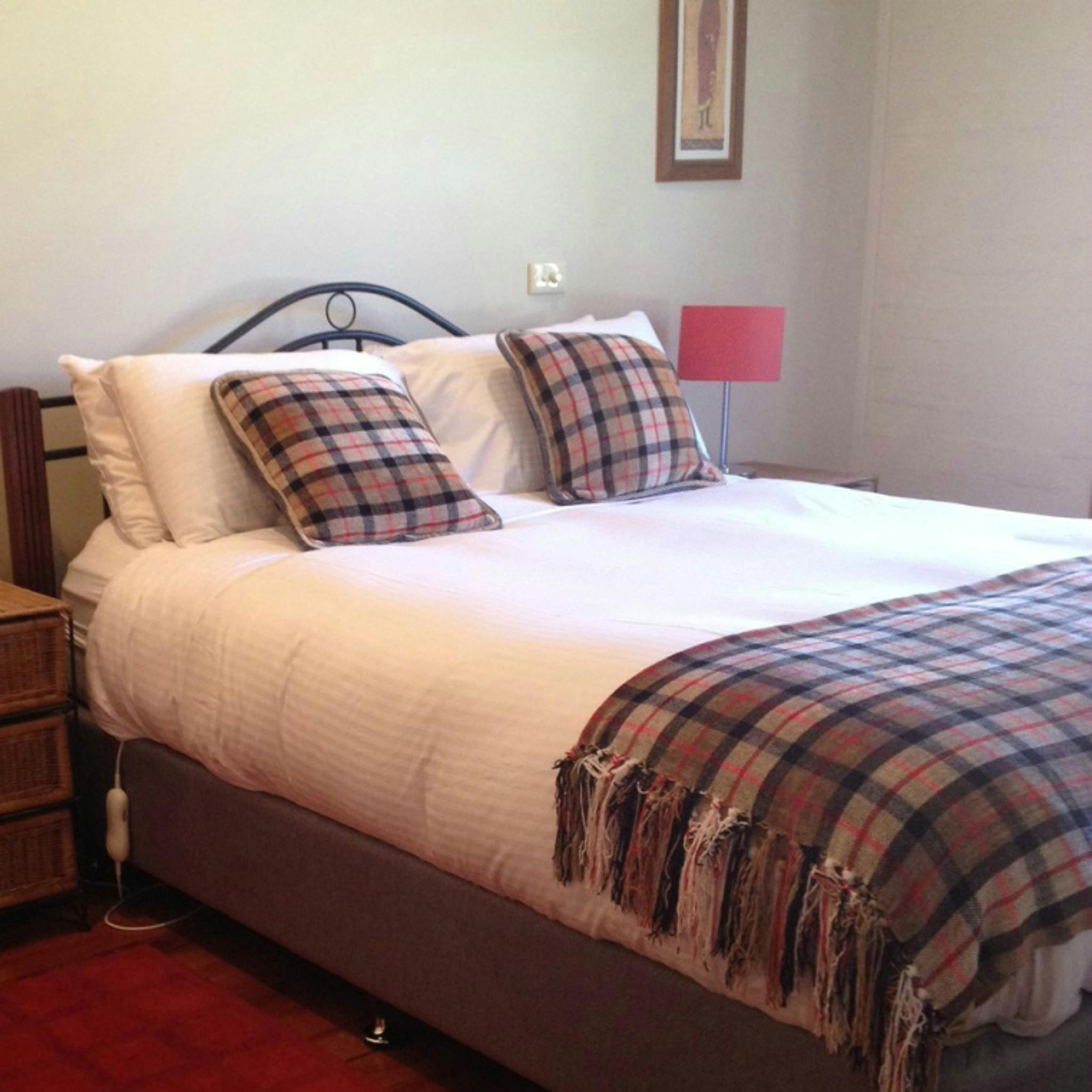 Photo shows the queen bed in one of the bedrooms