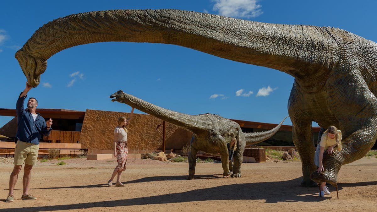 Guests with titanosaurs outside the "March of the Titanosaurs" exhibition