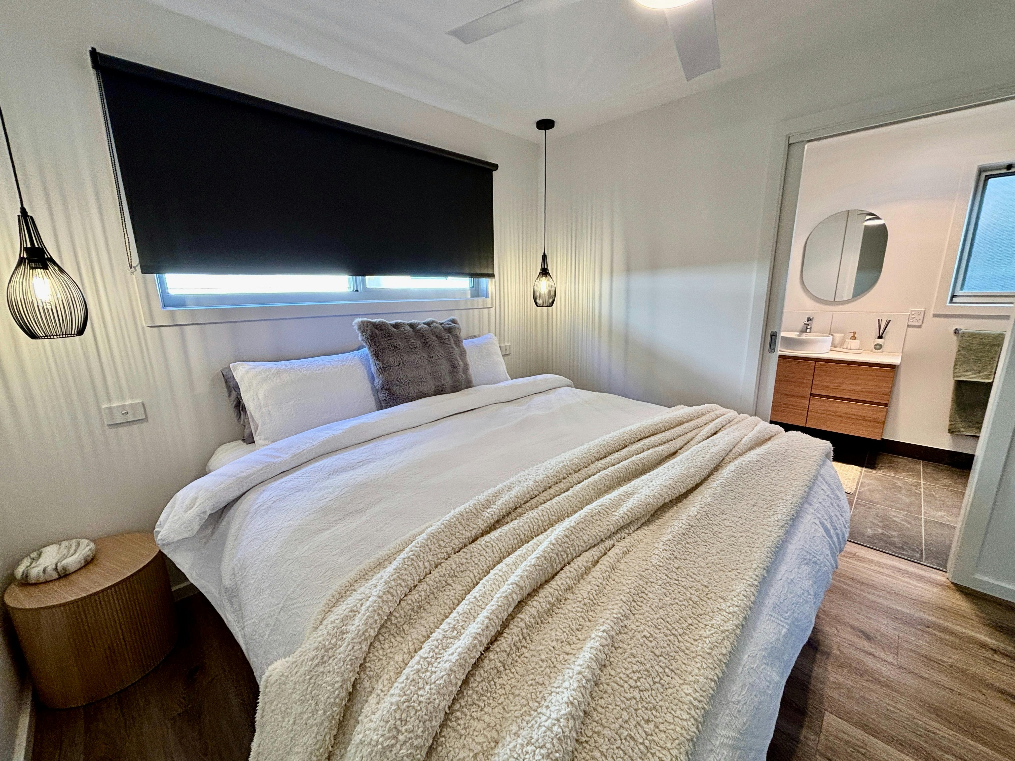 King bed with comfy doona, blankets, pillows and desk.