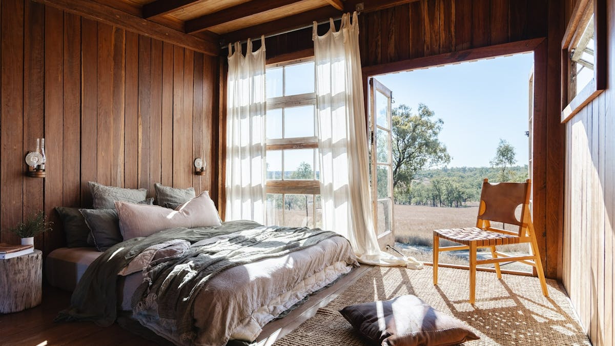 Image of Bloodwood Cabin bed overlooking natural landscape.