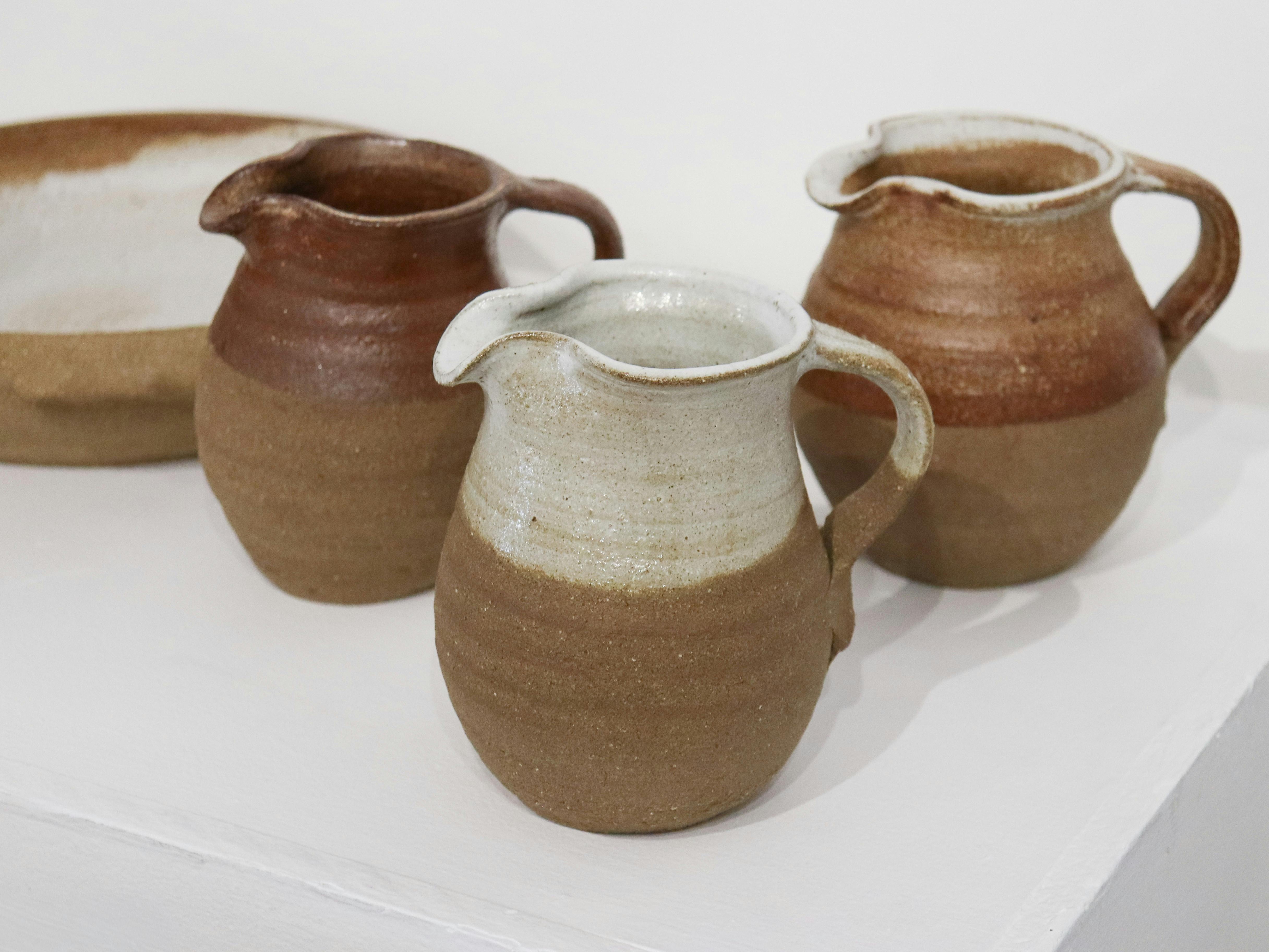 Wheel thrown ceramics jugs with partial glazing as part of buttlejorrk