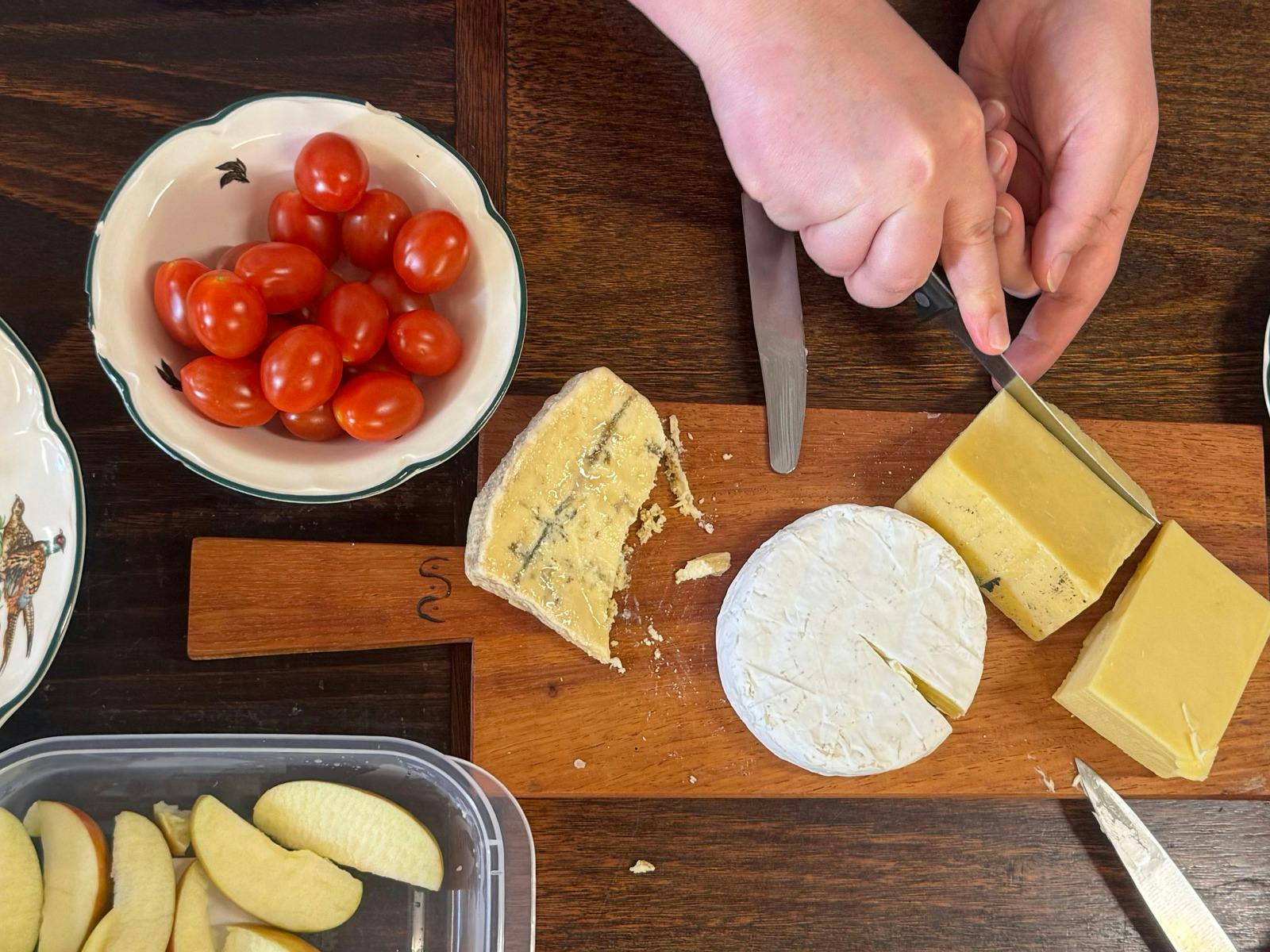 Triple cream brie, blue cheese, cheddar and havarti alongside tomatoes, apple and other snacks