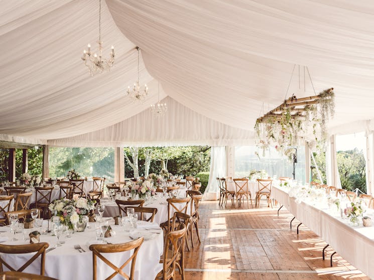 Pavilion hire with hoecker flooring, chandeliers with round table, linen and cross back chairs.