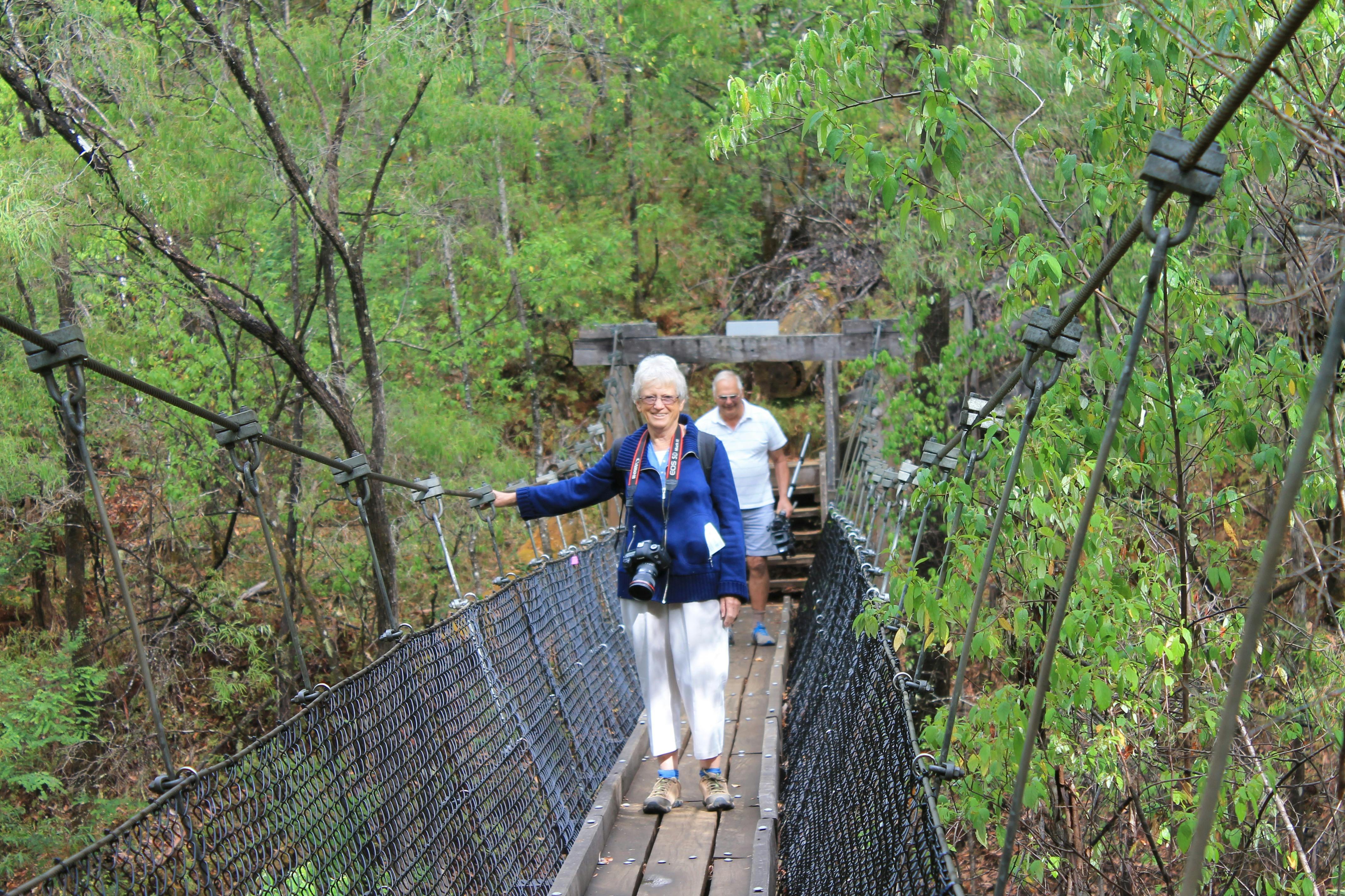 Couple walking across suspension bridge