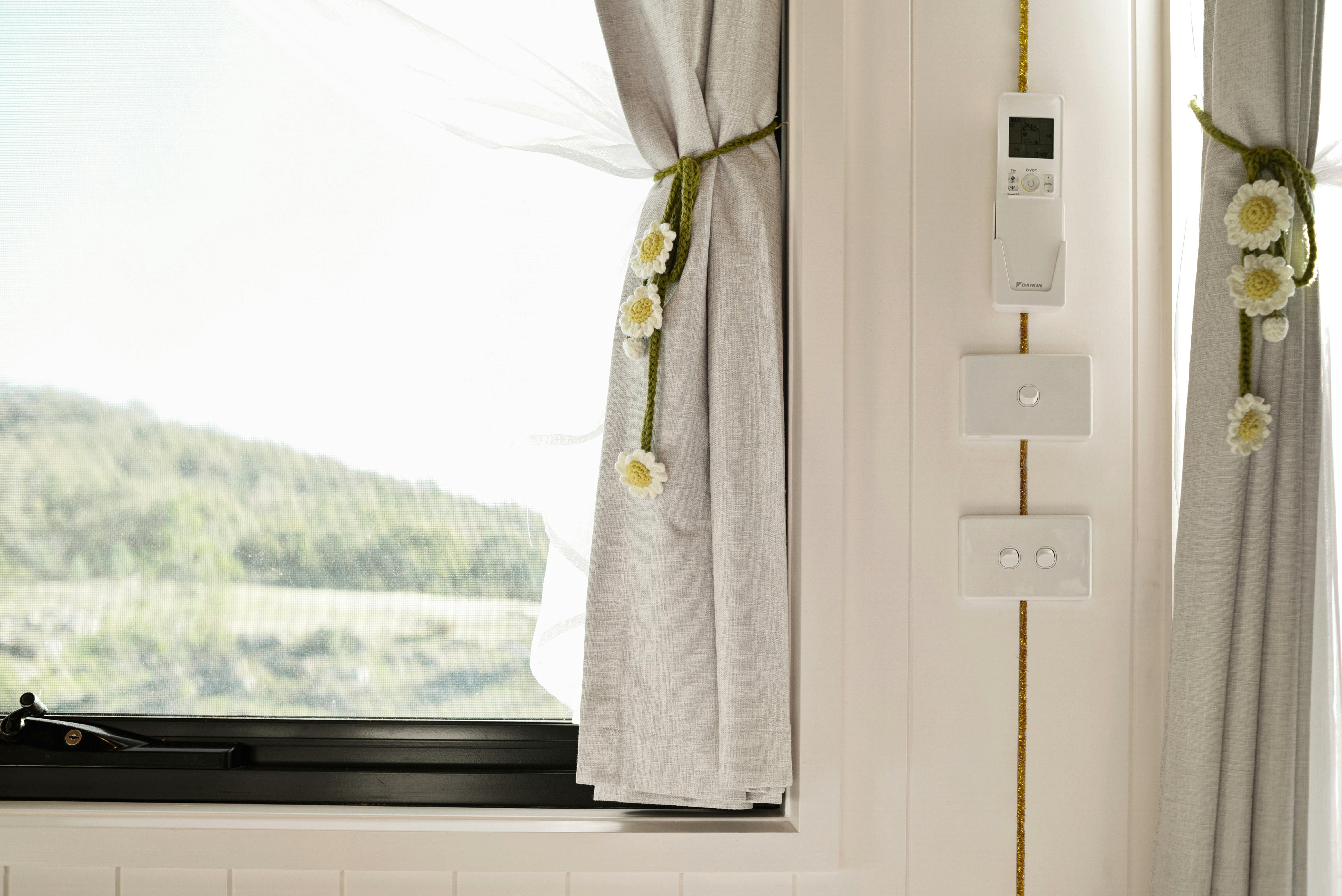 Window with curtain and a view across the landscape