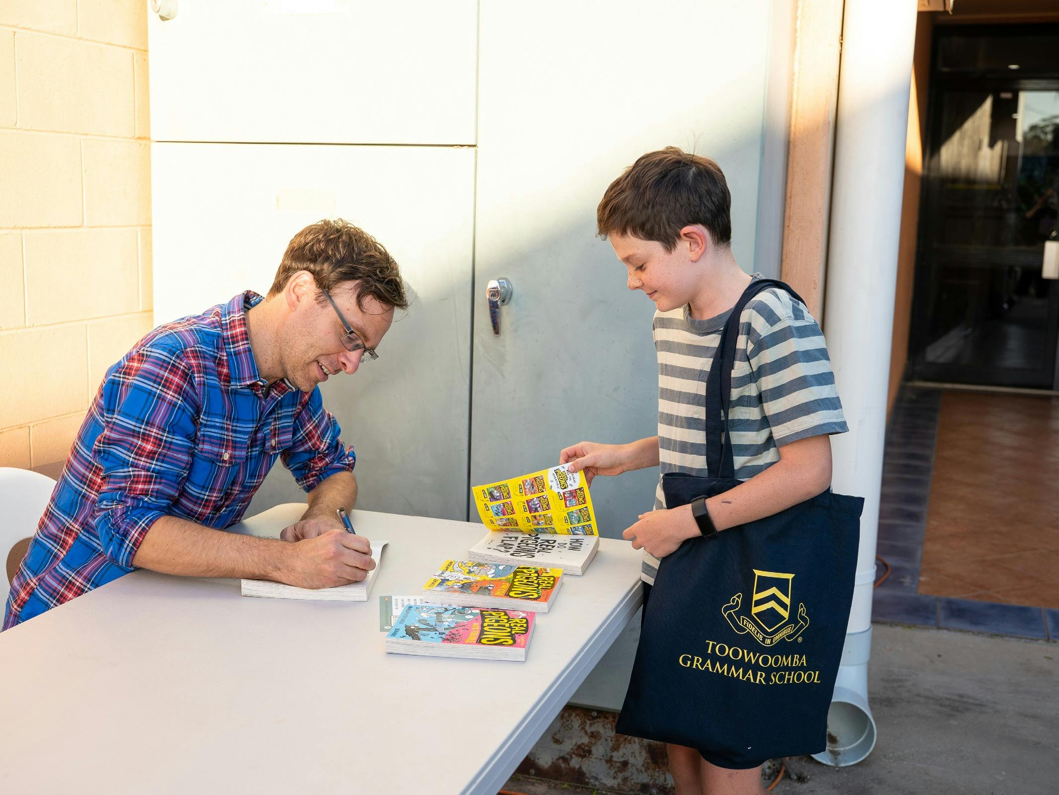 Young reader has a book signed by an author at the Storyfest Central QLD Prologue Party.