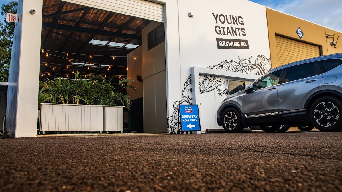 Young Giants Brewing entry —warehouse doors open, fresh craft beer inside. Young Giants Brewing entry —warehouse doors open, fresh craft beer inside.