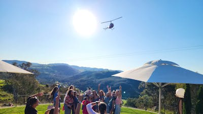 A cluster of individuals positioned in a field surrounded by nature
