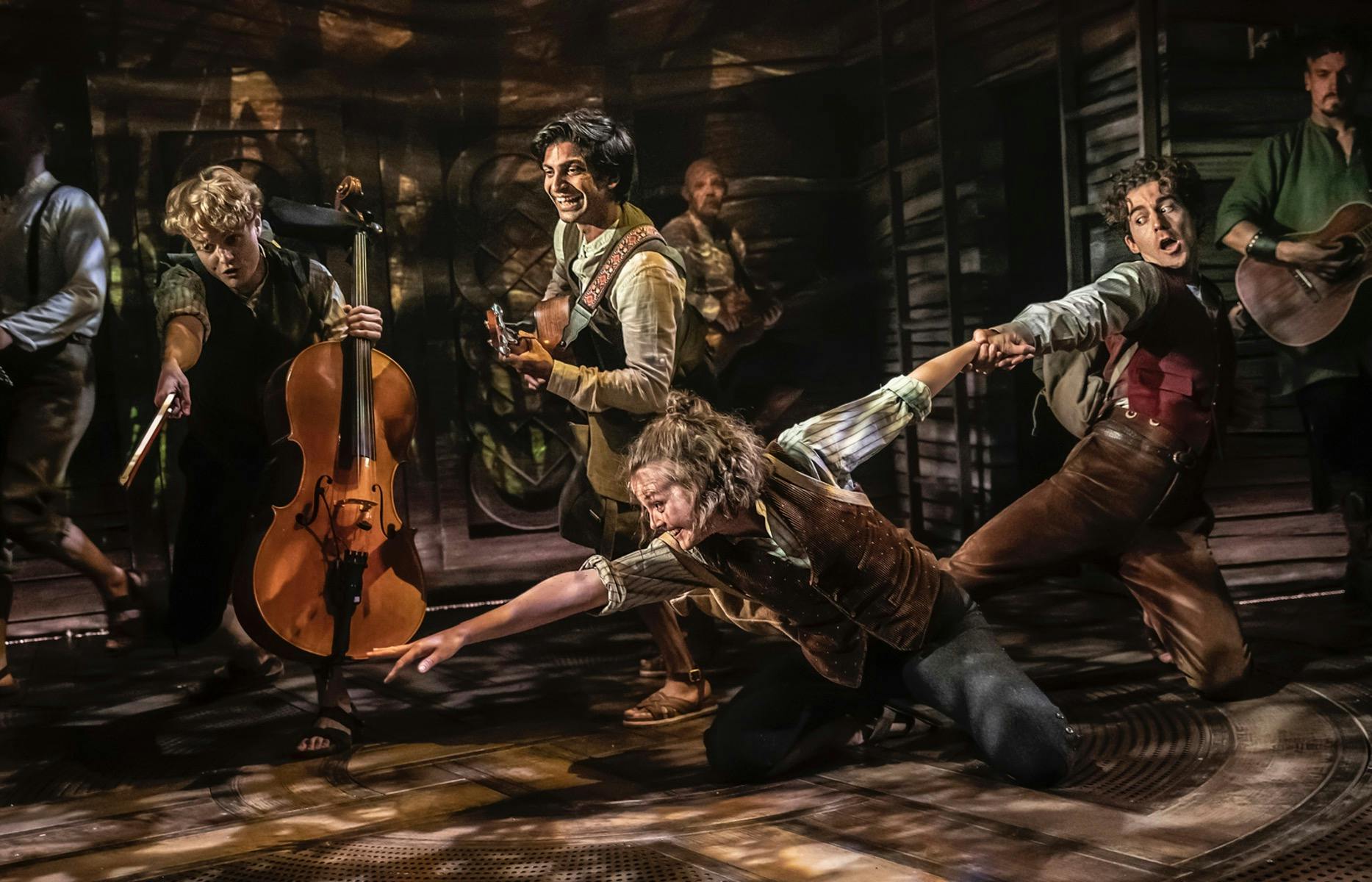 A group of Hobbits playing music, One is reaching for something.