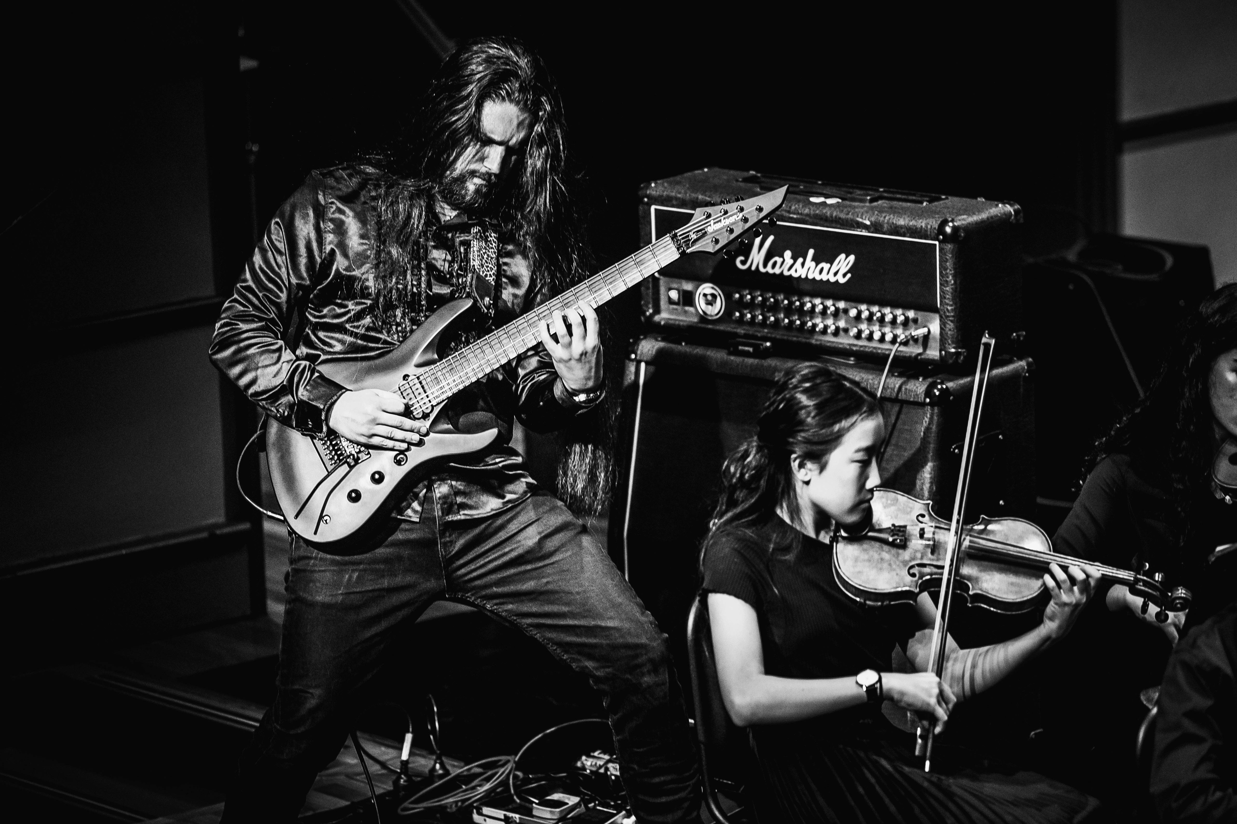 Black and white image of guitarist and young violin player