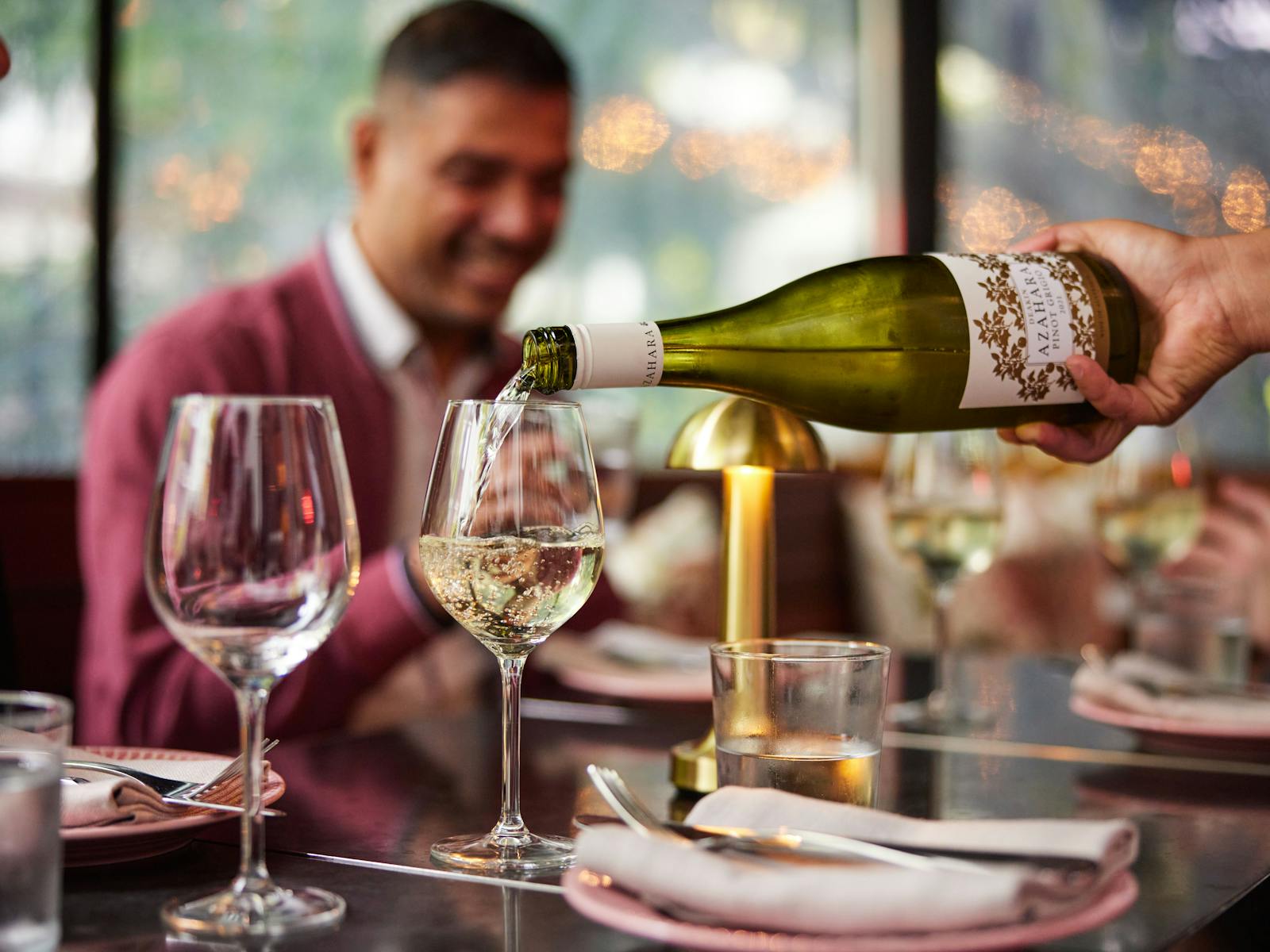 웨이터는 백그라운드에서 와인 손님 미소를 따른다