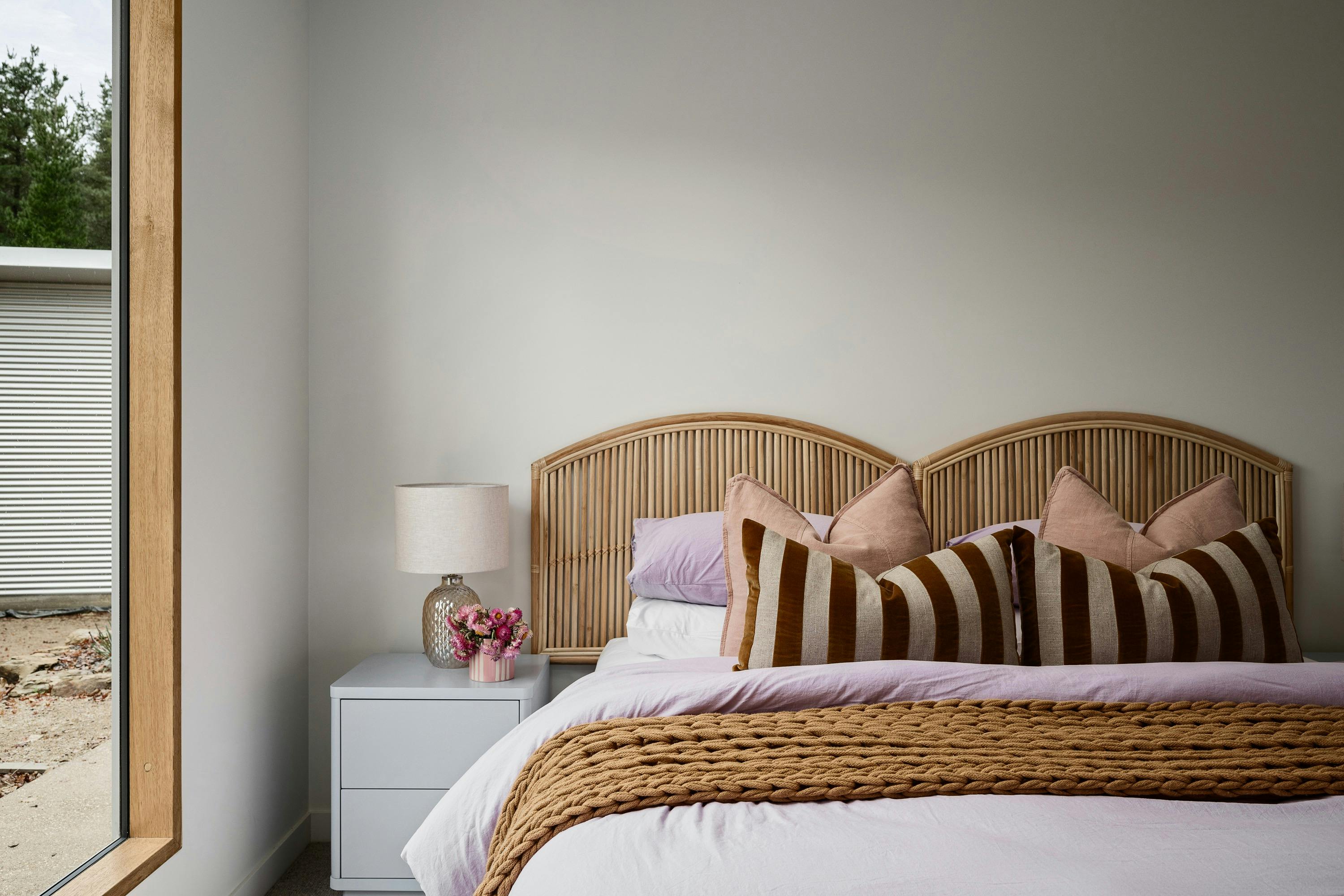 silver house, bedroom with colourful pillows and a bedside table