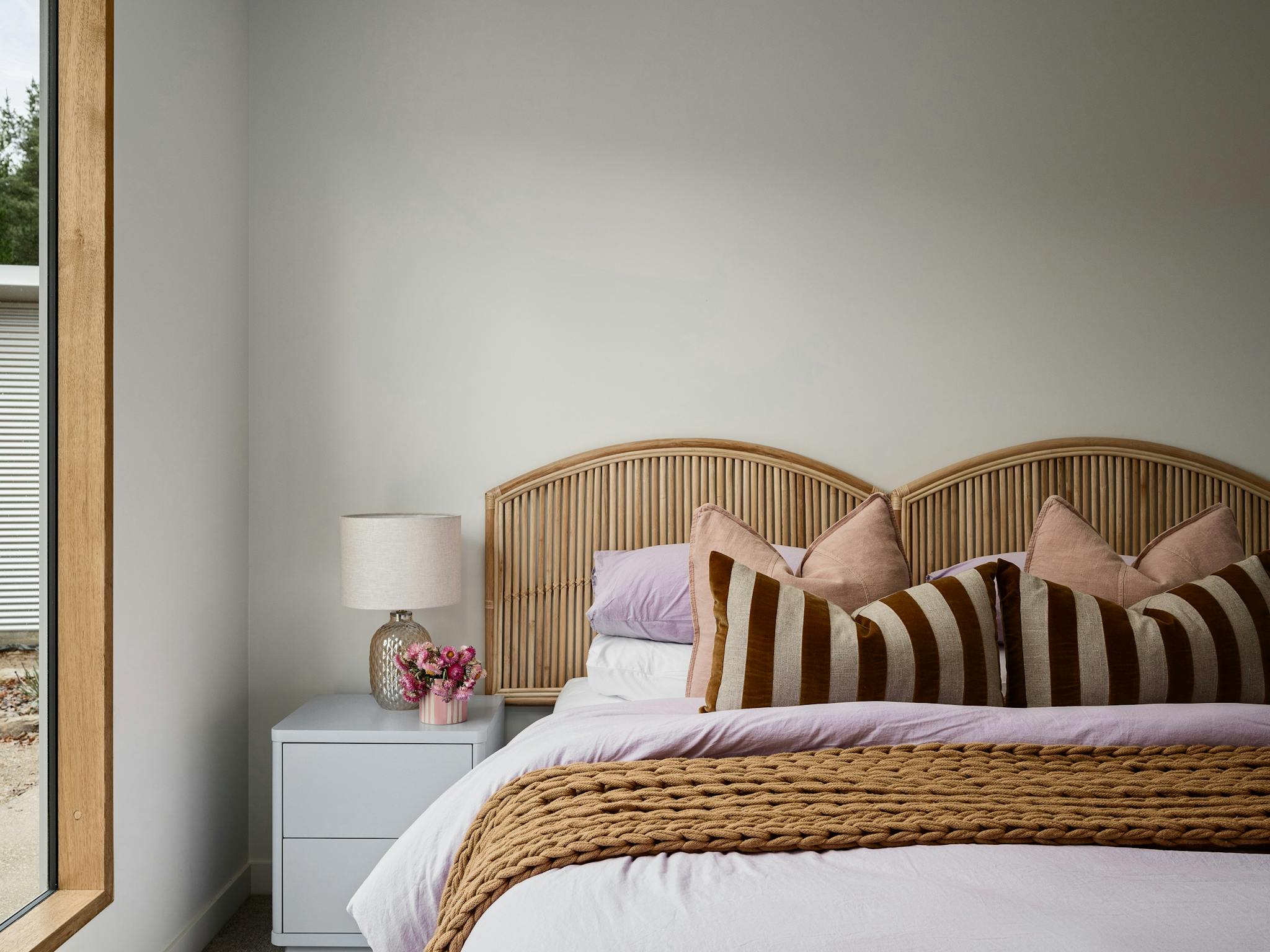 silver house, bedroom with colourful pillows and a bedside table