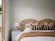 silver house, bedroom with colourful pillows and a bedside table