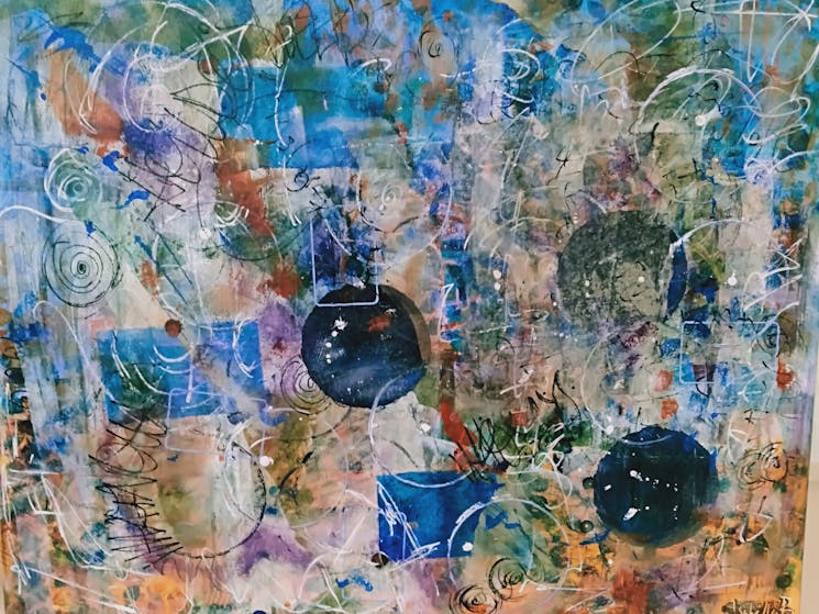 Abstract acrylic painting with various shades of blue, circles, shapes, and scribbles.