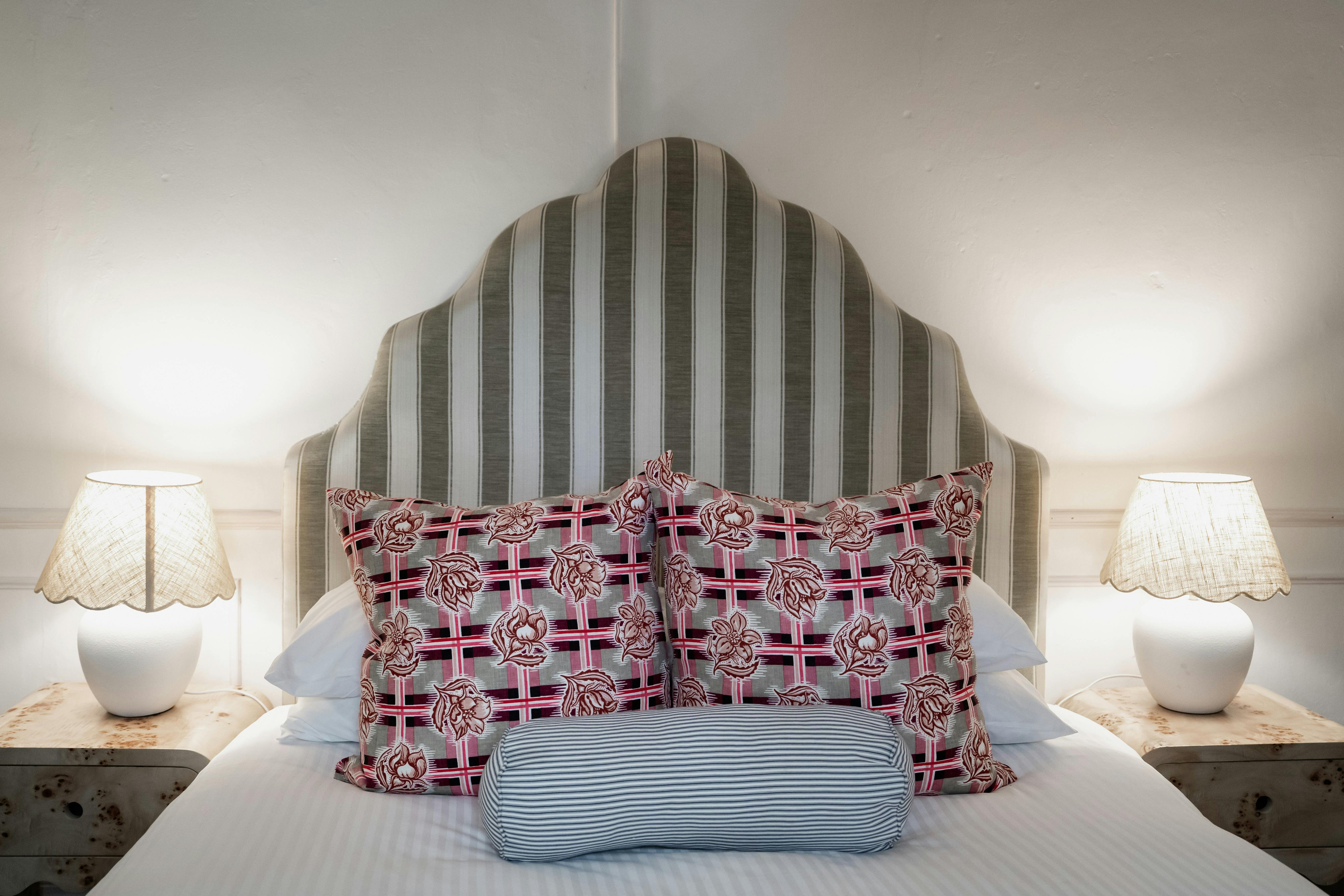 패턴이 있는 쿠션과 램프가 있는 맞춤형 침대 머리판