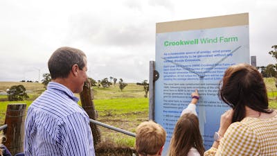 Family reading wind farm signage