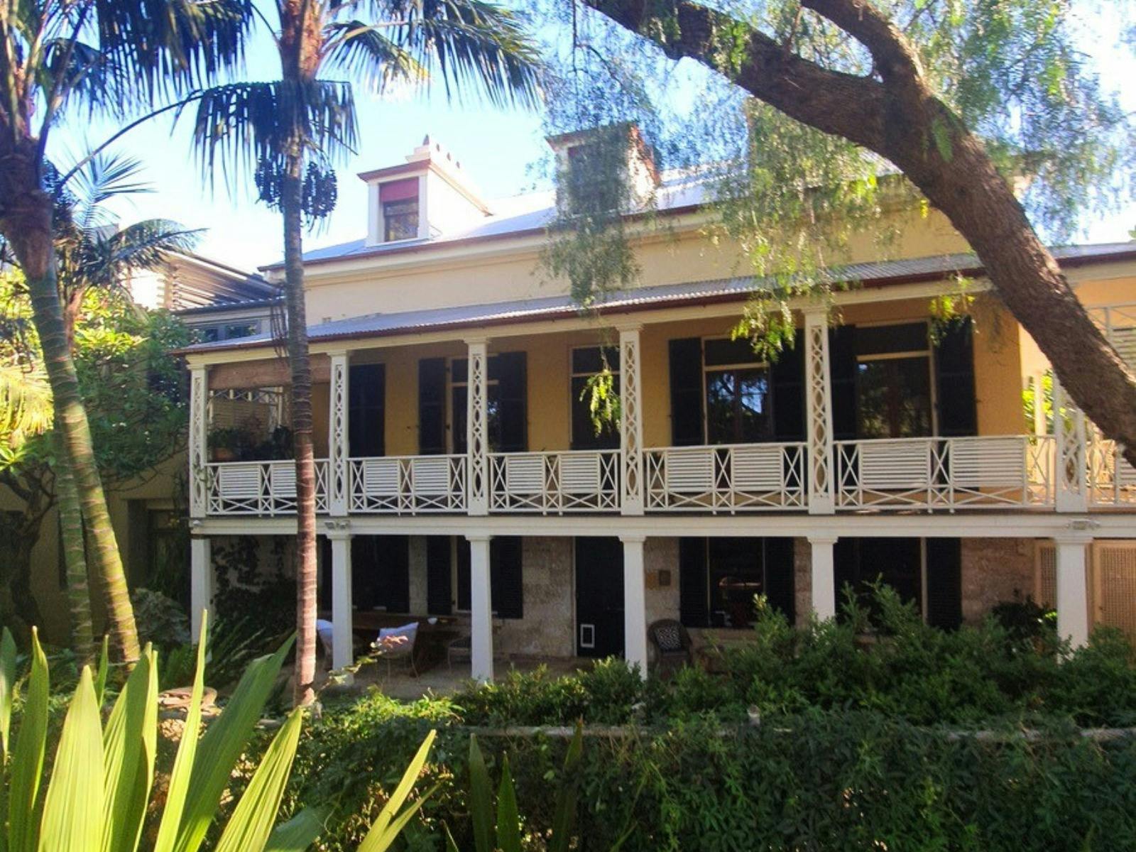 Double storey historic house with elaborate balcony and three chimneys