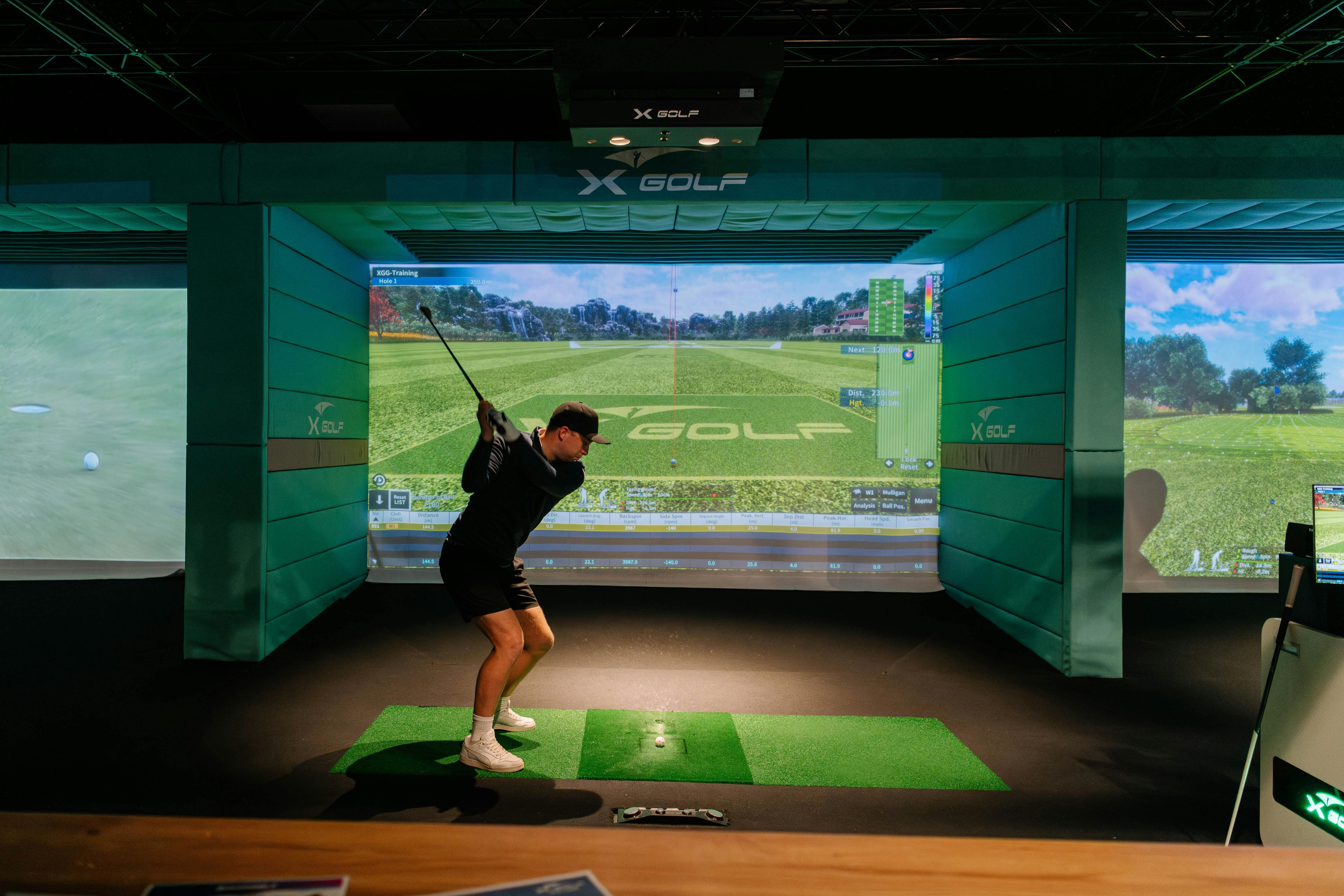 a man swinging a golf club in front of a digital screen