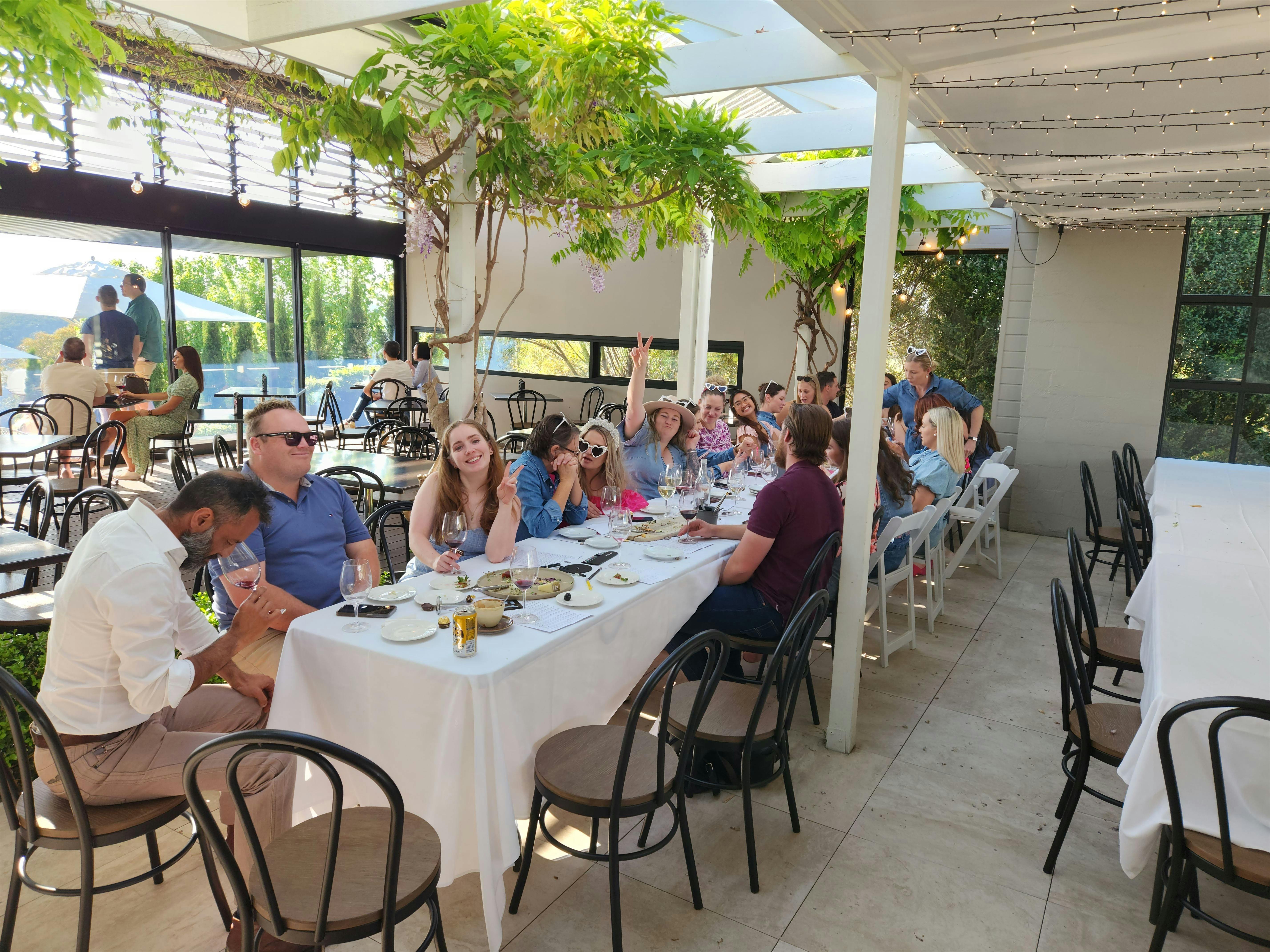 A group of individuals gathered around a table, engaged in conversation and enjoying a meal together