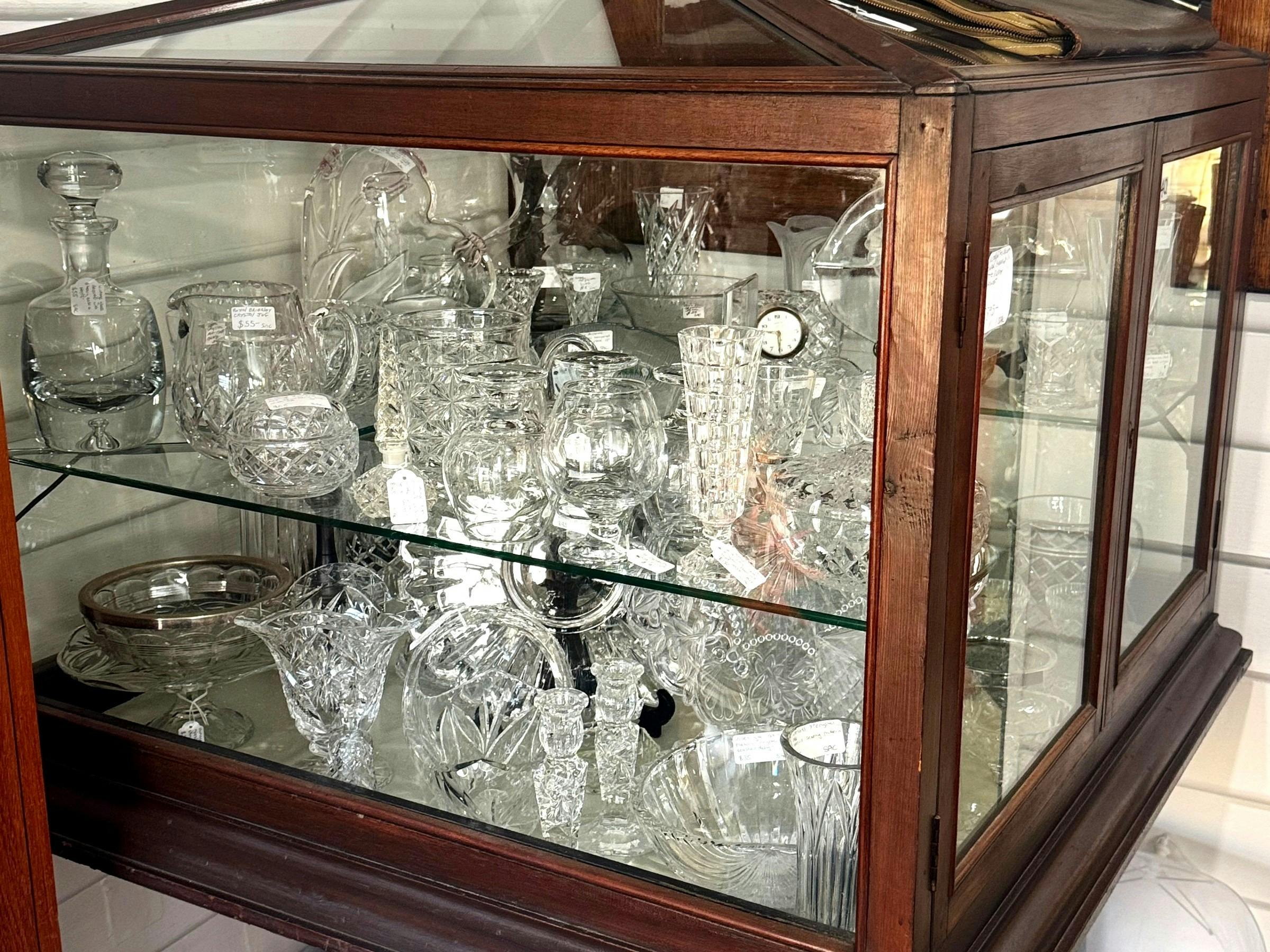 Timber display cabinet filled with cut crystal glassware and decanters