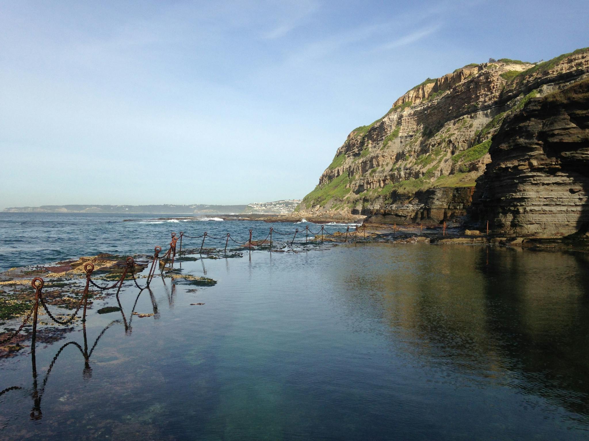 A seaside pool called the Bogey Hole dug into a rock platform underneath cliffs