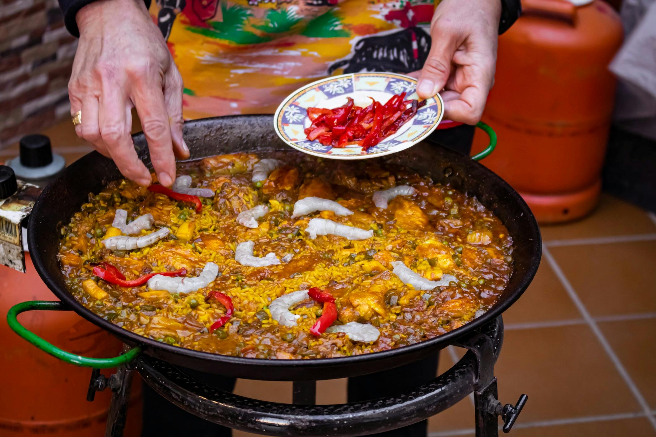 Cooking Paella with fresh chilli and prawns on top.