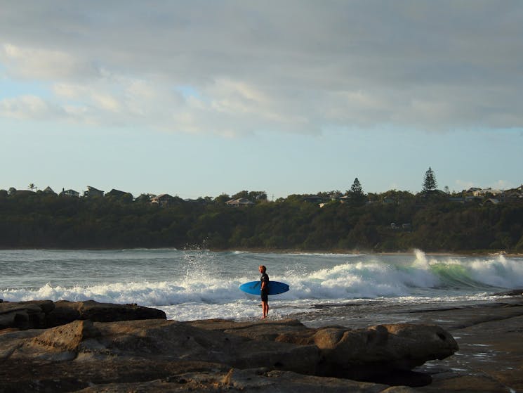 Young local surfer waits for a lull. Green Point, with Spooky Beach in background.