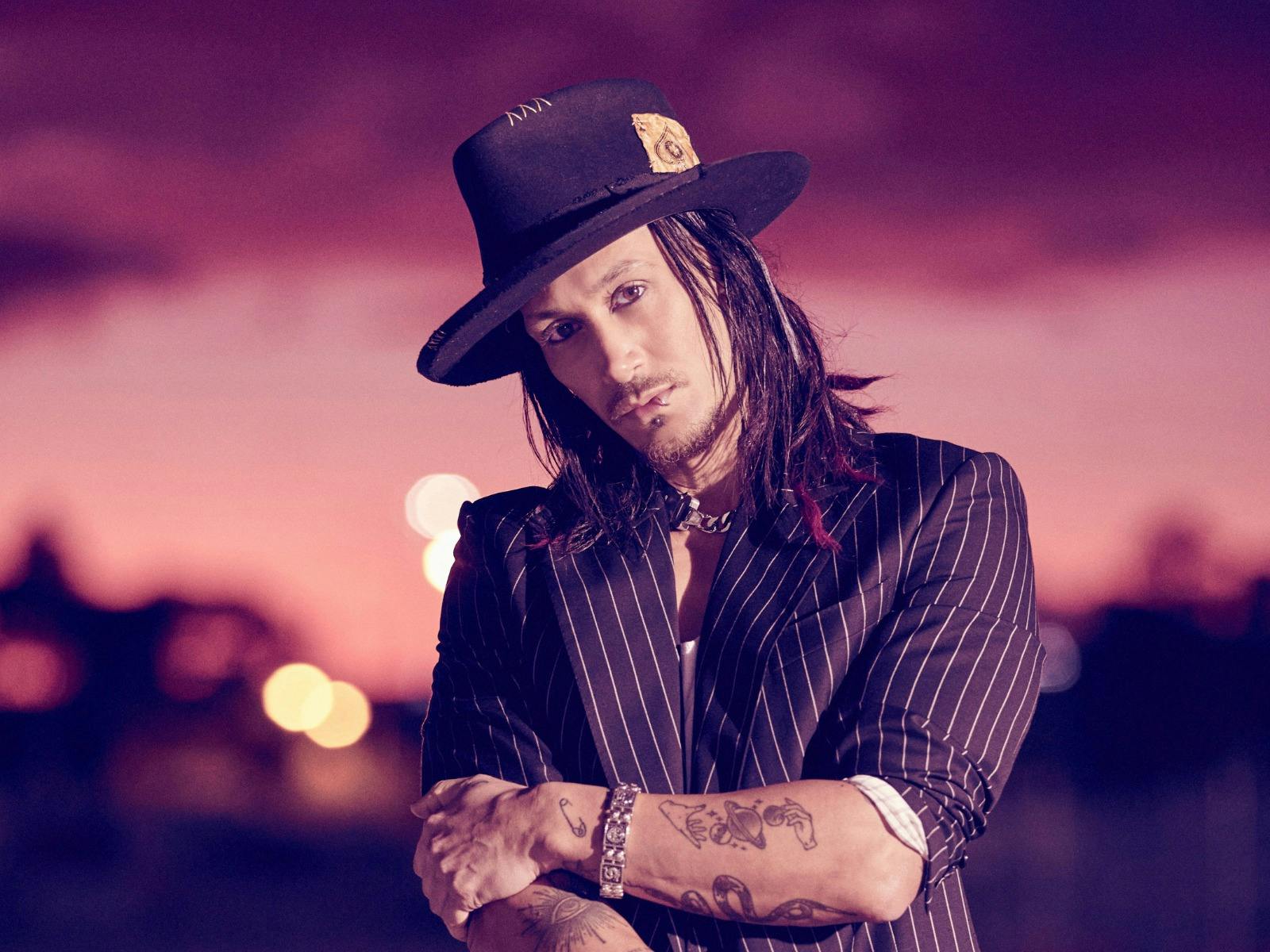 Magician Cosentino in an outdoor space, the sky is a purple colour