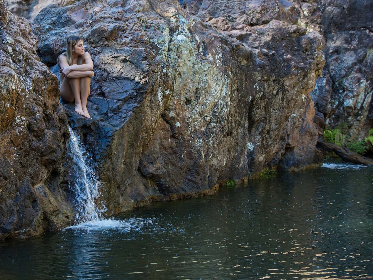 Woman sitting on the rocks at Rocky Hole