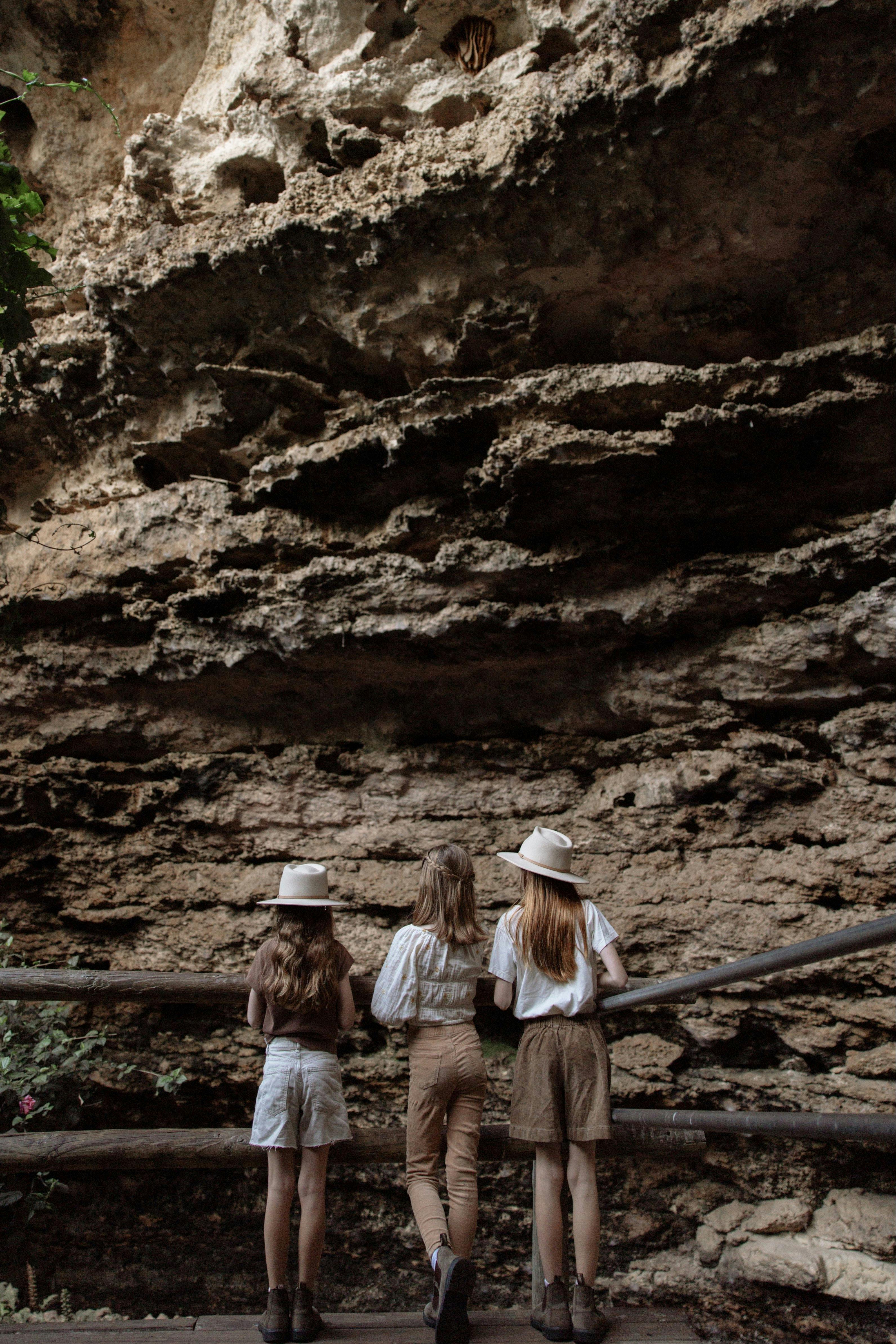 Children standing behind fence looking at rock formations